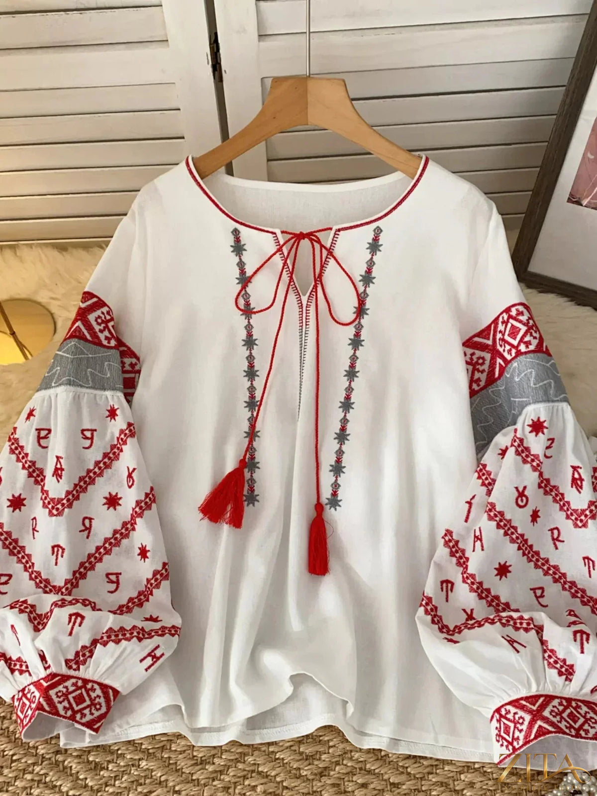 Zita La Belle Elite embroidered tie-neck blouse with floral details, featuring long sleeves and a relaxed fit, on a white background.