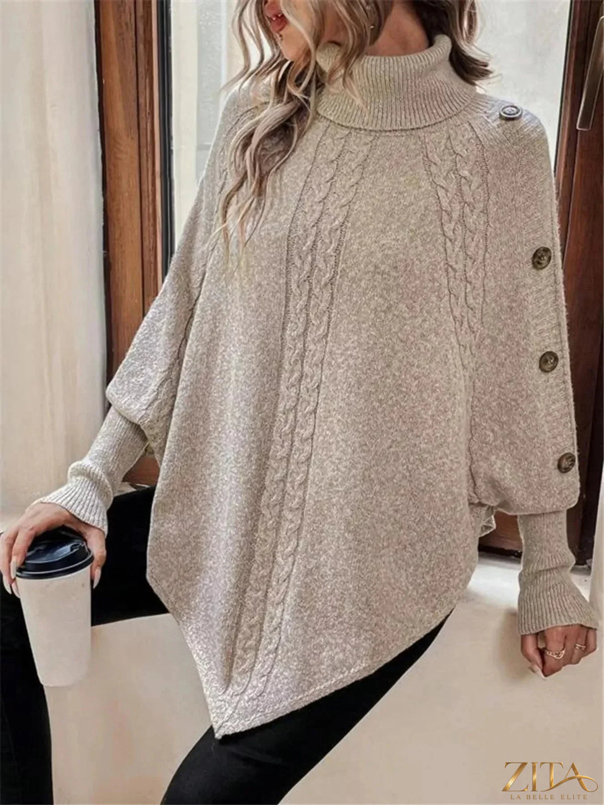 Cable knit turtleneck cape sweater by Trendsi, featuring a cozy, textured design with a high neckline and flowing cape style.