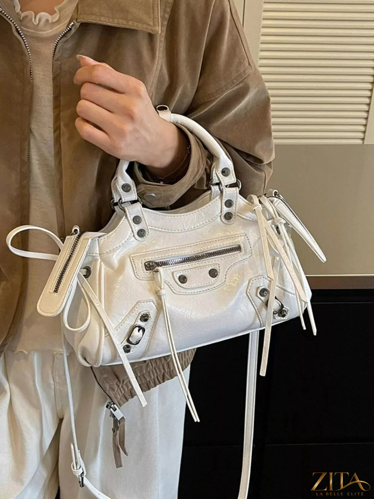 Leather tassel handbag by Trendsi with adjustable strap, featuring a stylish design and spacious interior for everyday use.