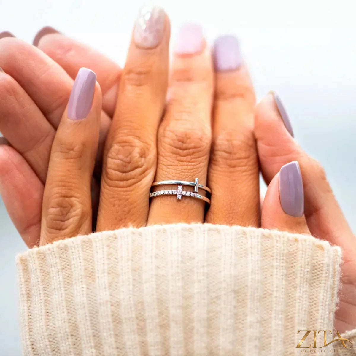Silver double band cross ring by Zita La Belle Elite featuring overlapping bands and a small cross detail.