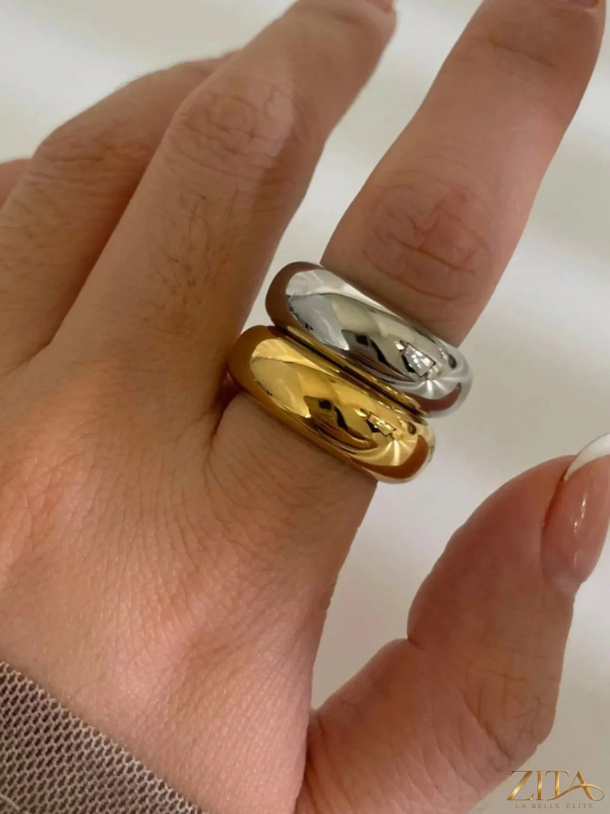 Two 18K gold-plated stainless steel dome band rings from Zita La Belle Elite, close-up view highlighting smooth, shiny surfaces.