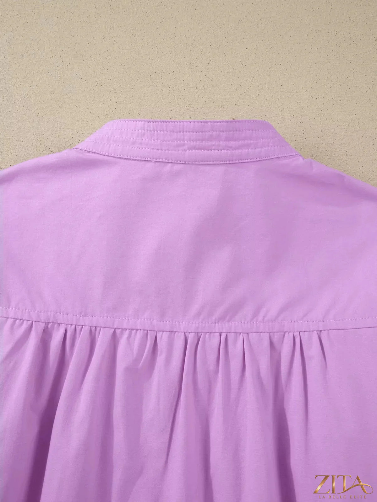 Zita La Belle Elite notched puff sleeve blouse with ruffled details and lightweight fabric, styled on a hanger.