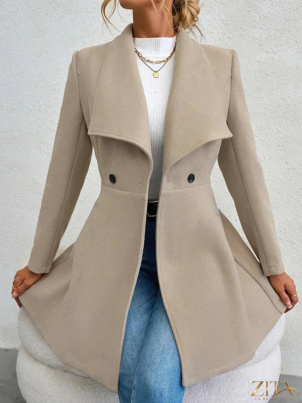Zita La Belle Elite collared neck button-up long sleeve coat hanging on a wooden hook, showcasing classic style and tailored fit.