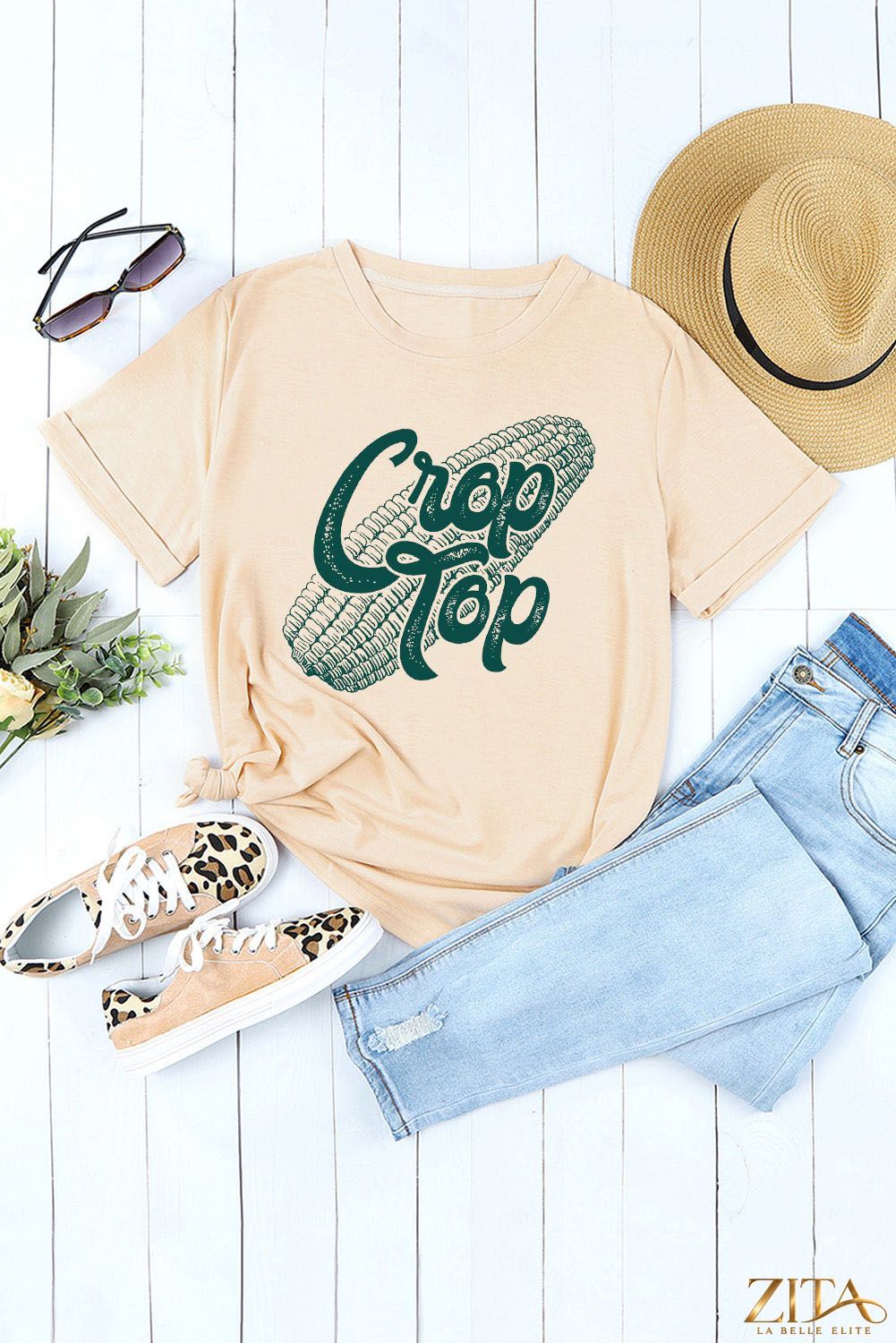 Corn Letter Graphic Cuffed T-Shirt by Trendsi featuring a playful corn graphic and cuffed short sleeves in a casual style.