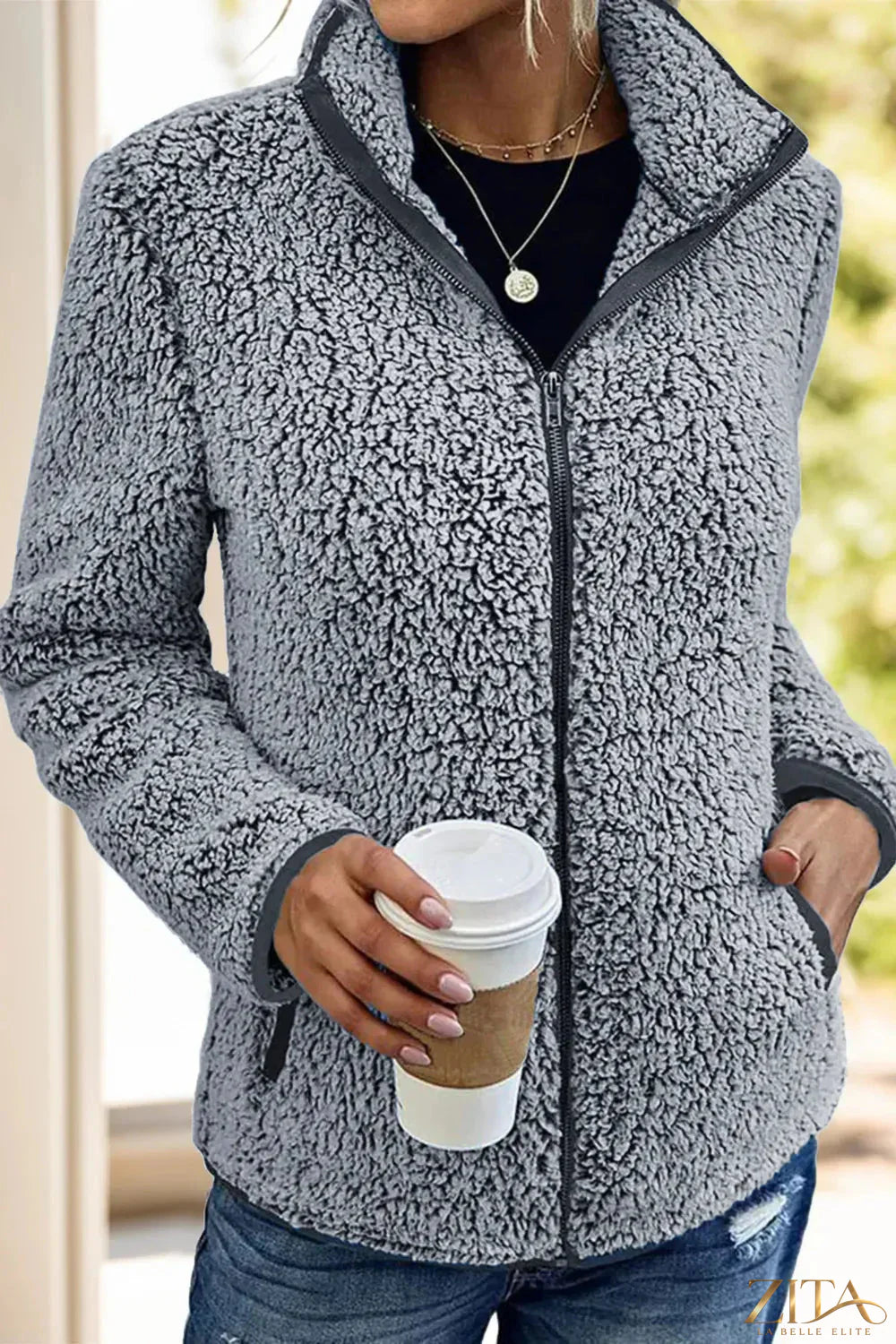 Black pocketed zip-up turtleneck jacket by Trendsi, featuring a fitted design, front pockets, and a high collar for warmth.