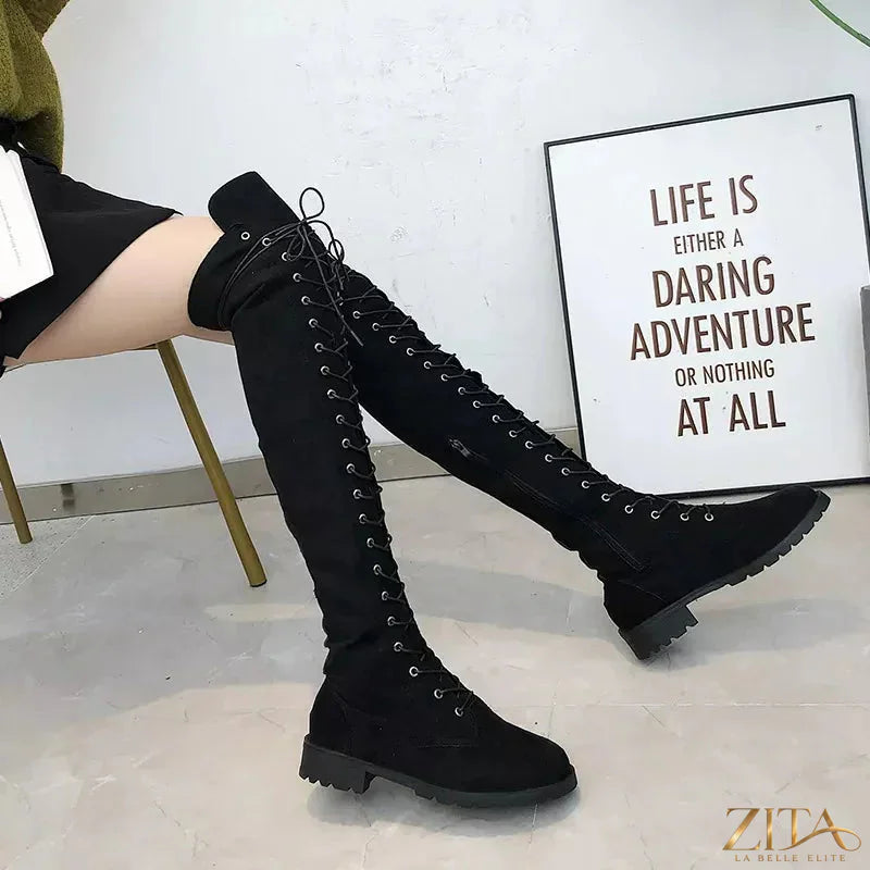 Black lace-up over-the-knee boots by Trendsi with high heels and sleek design, shown on a model standing on a city street.