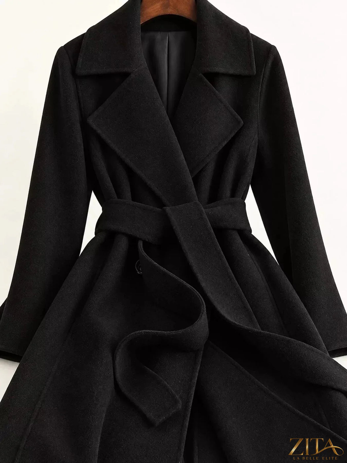 Longline wool coat by Zita La Belle Elite featuring a waist-defining belt and classic tailored silhouette.