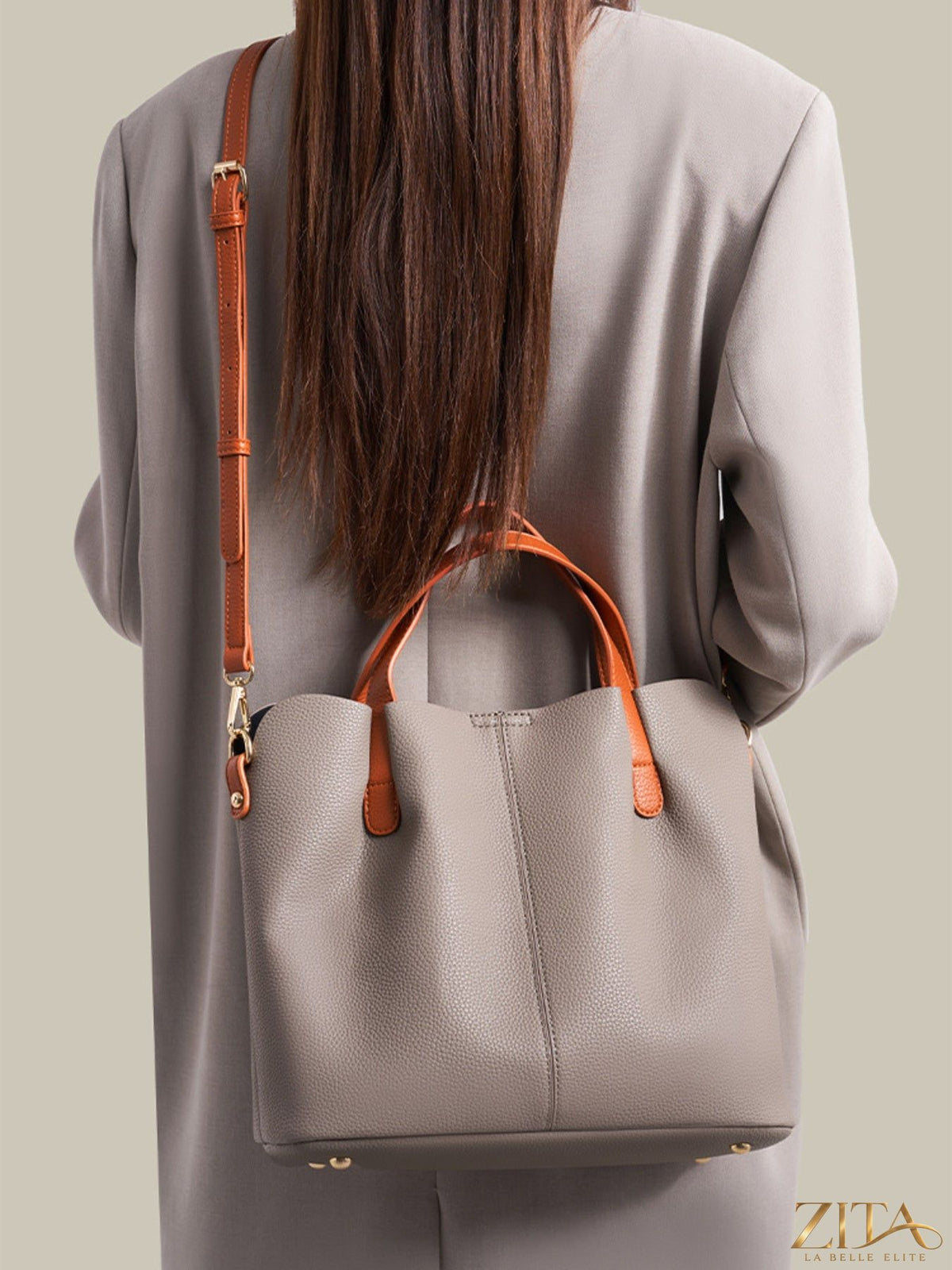 Leather contrast handle handbag with sleek design and sturdy straps, featuring a stylish, modern look in neutral tones.