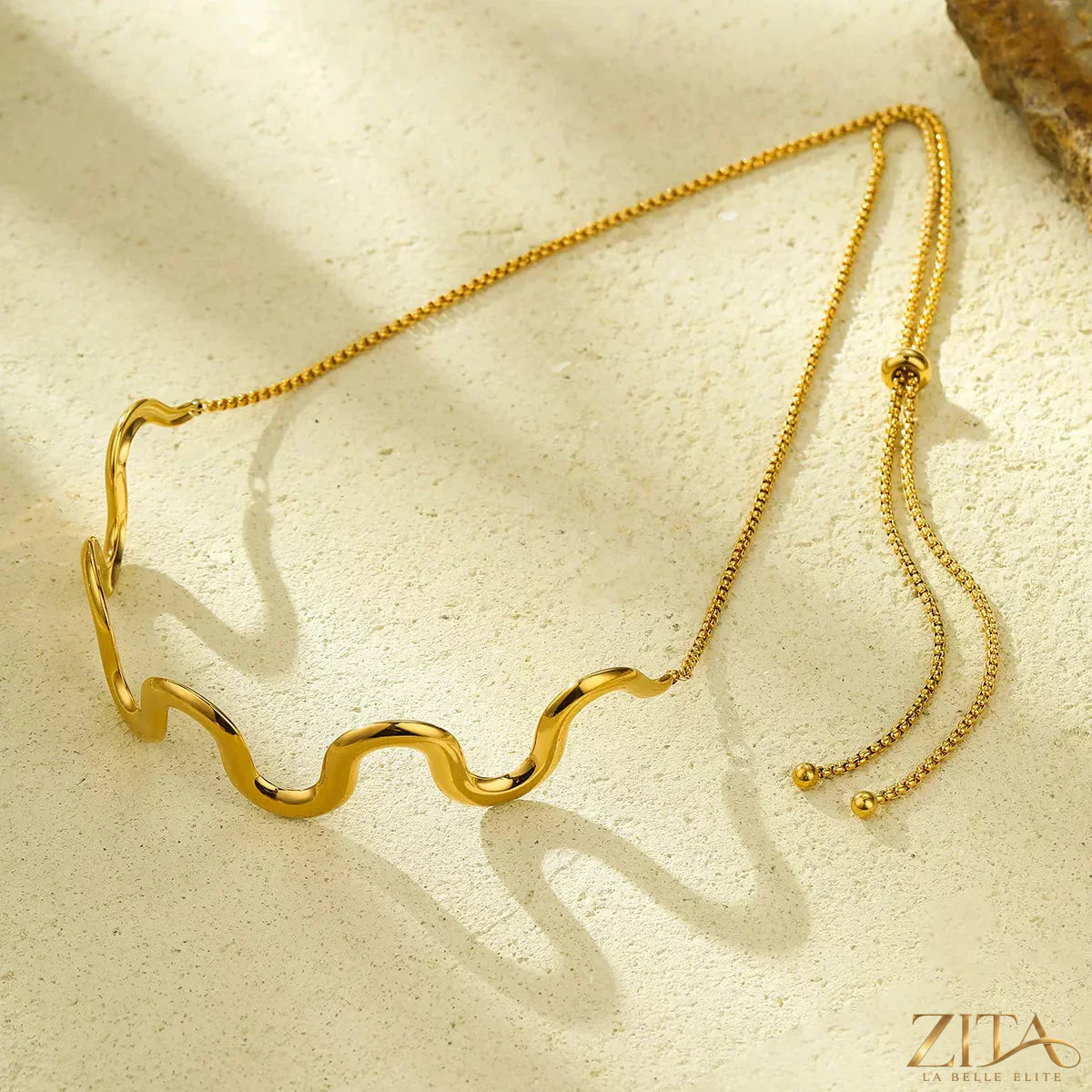 18K gold-plated wave necklace from Zita La Belle Elite with a sleek, flowing design, displayed on a neutral background.