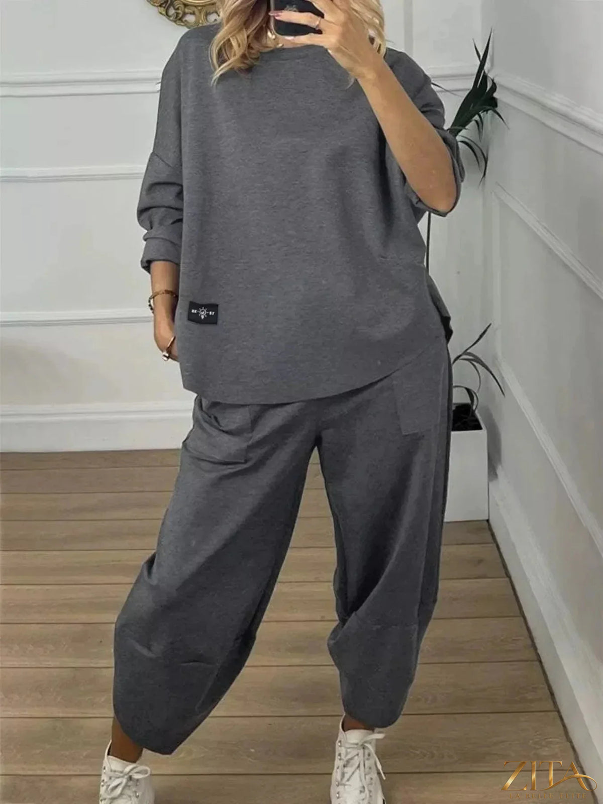 Plus size casual loose fit top and pants two-piece set by Trendsi, featuring comfortable, relaxed fit clothing in neutral fabric.