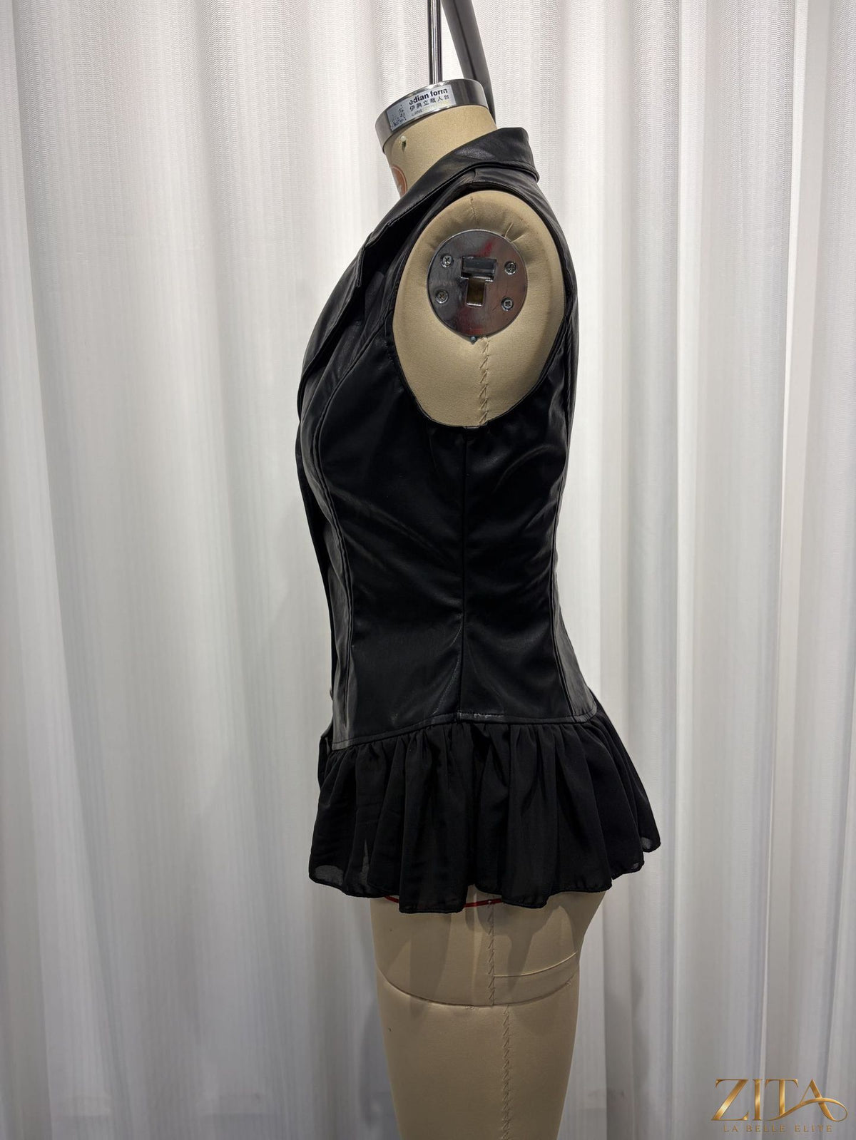 Black PU leather vest by Zita La Belle Elite featuring deep V neckline, ruffle hem, and fitted waist, Gothic style tops.