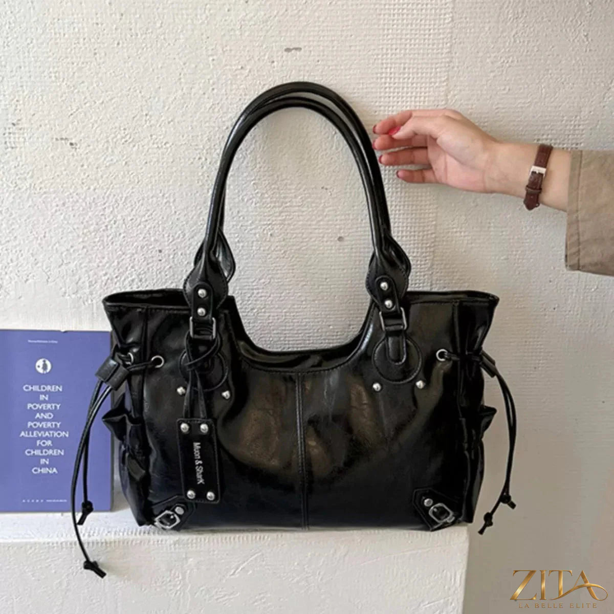 Drawstring leather handbag by Trendsi featuring a sleek design, adjustable strap, and stylish leather finish.