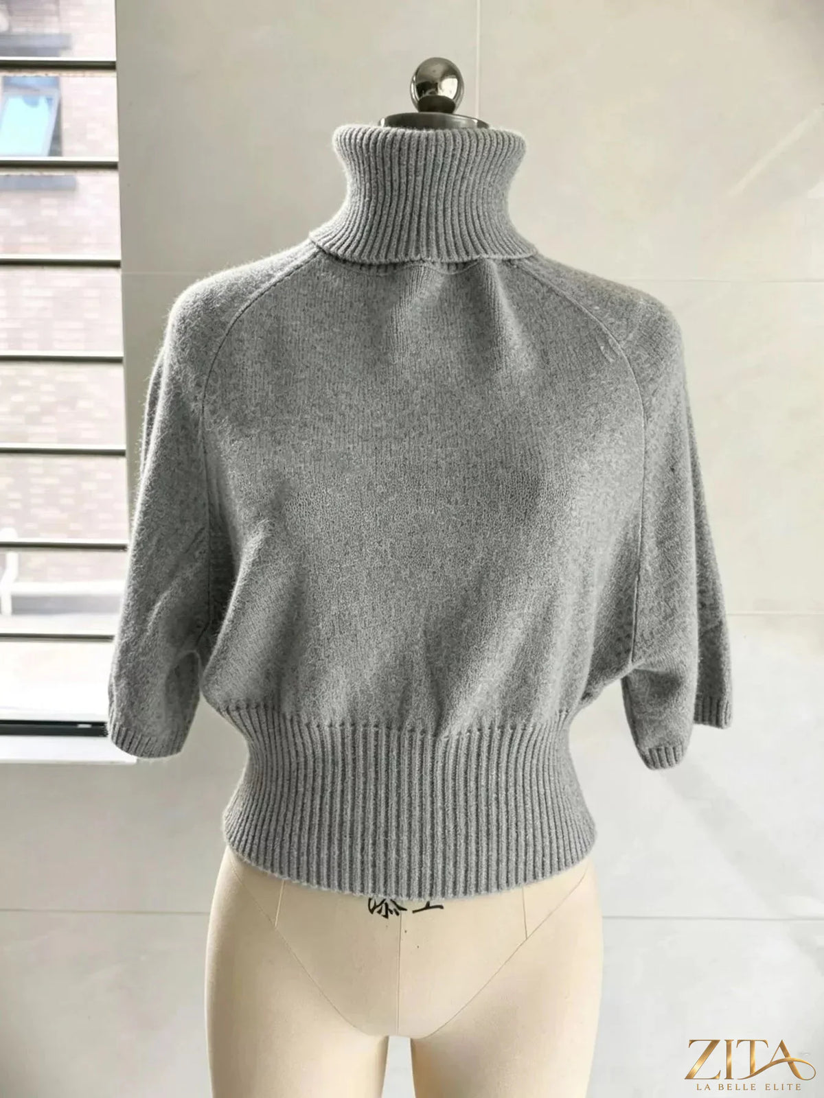 Light beige turtleneck sweater with batwing sleeves from Trendsi, featuring a cozy, stylish design perfect for fall and winter wear.