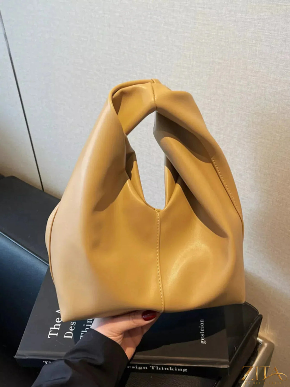 Zita La Belle Elite knot handle leather handbag featuring a sleek design and elegant leather texture.