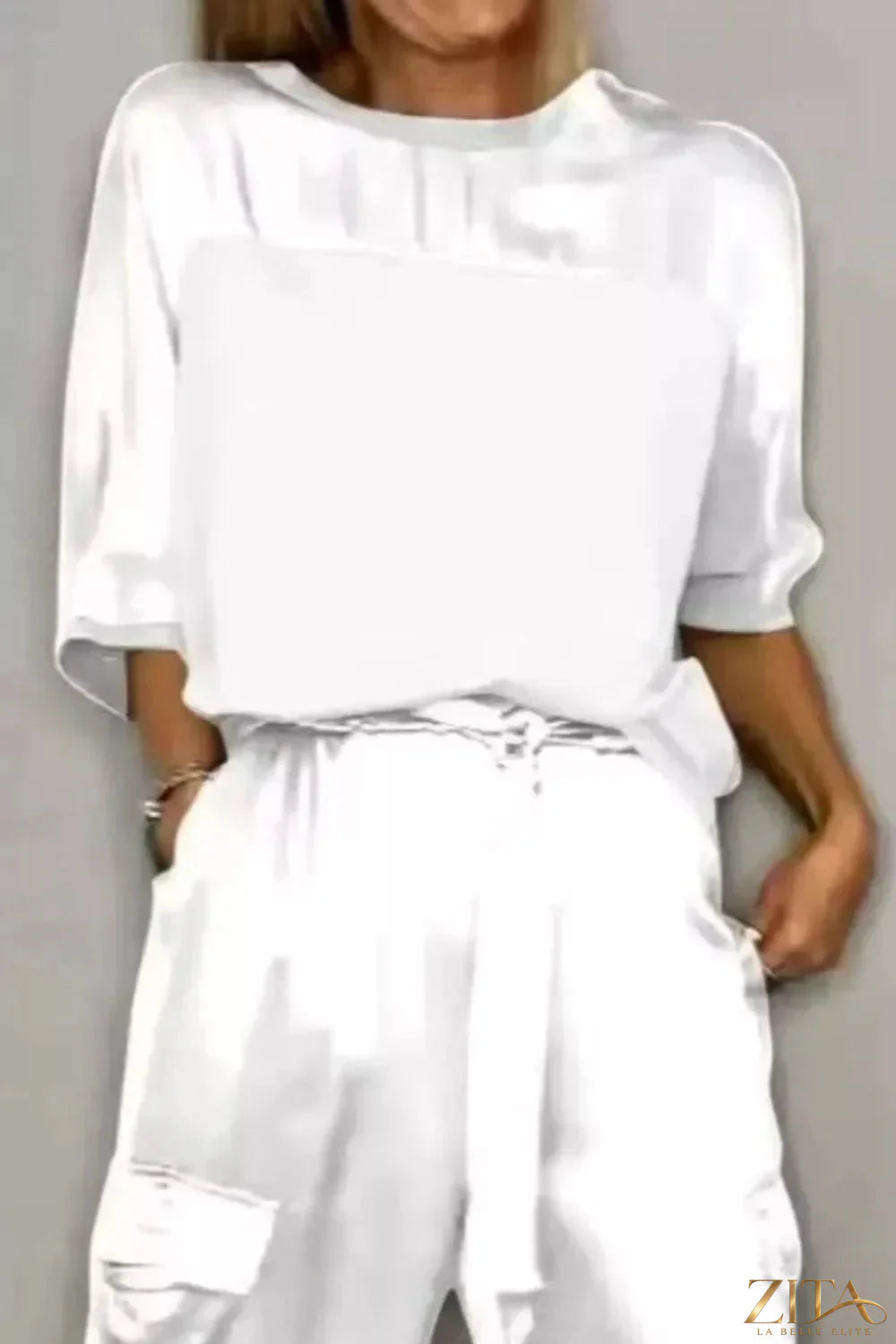 Satin round neck top and matching pants set by Trendsi, featuring a smooth, shiny fabric and relaxed fit on a model.