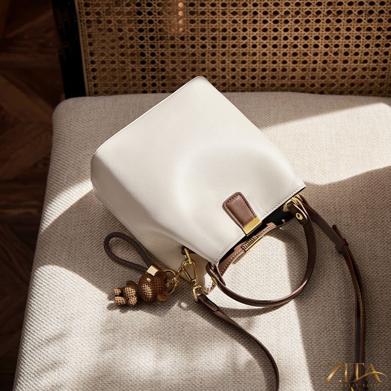 Leather bucket crossbody bag by Trendsi featuring a sleek, rounded design with a shoulder strap and stylish leather finish.