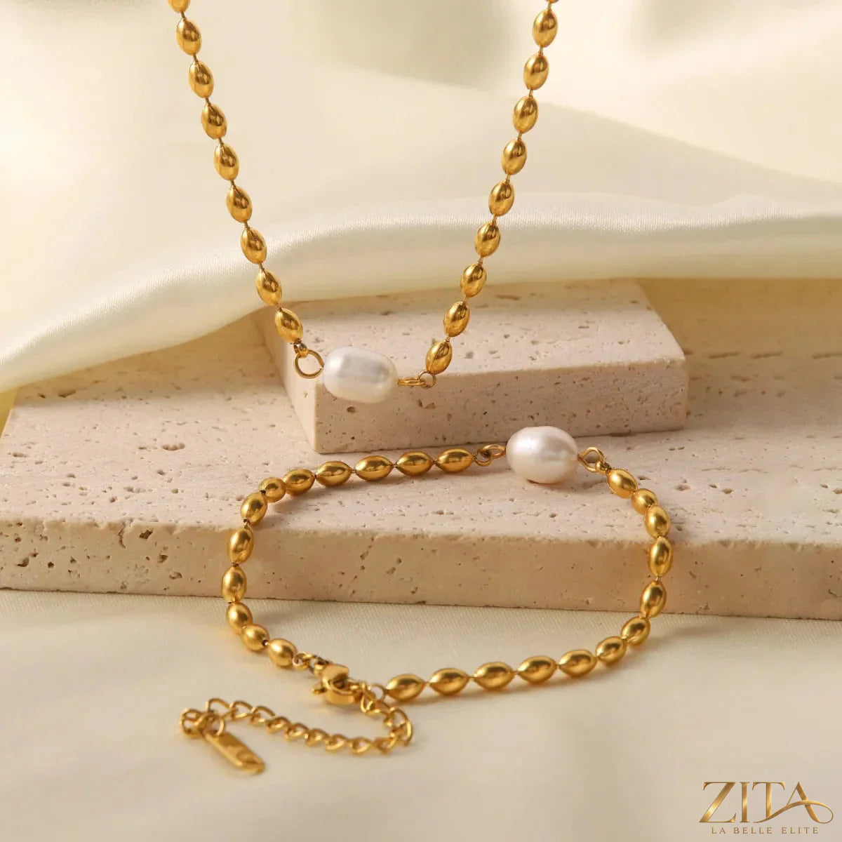 Pearl and gold chain jewelry set with matching necklace and bracelet, featuring elegant pearl accents and gold links.