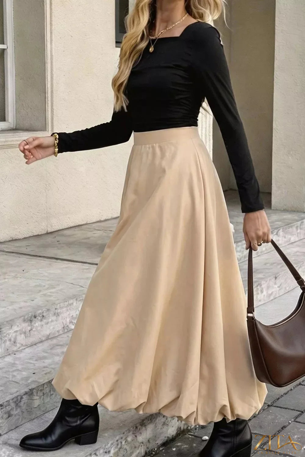 High-waisted A-line midi skirt by Trendsi, featuring a flowing fabric and classic silhouette, shown in a stylish neutral color.