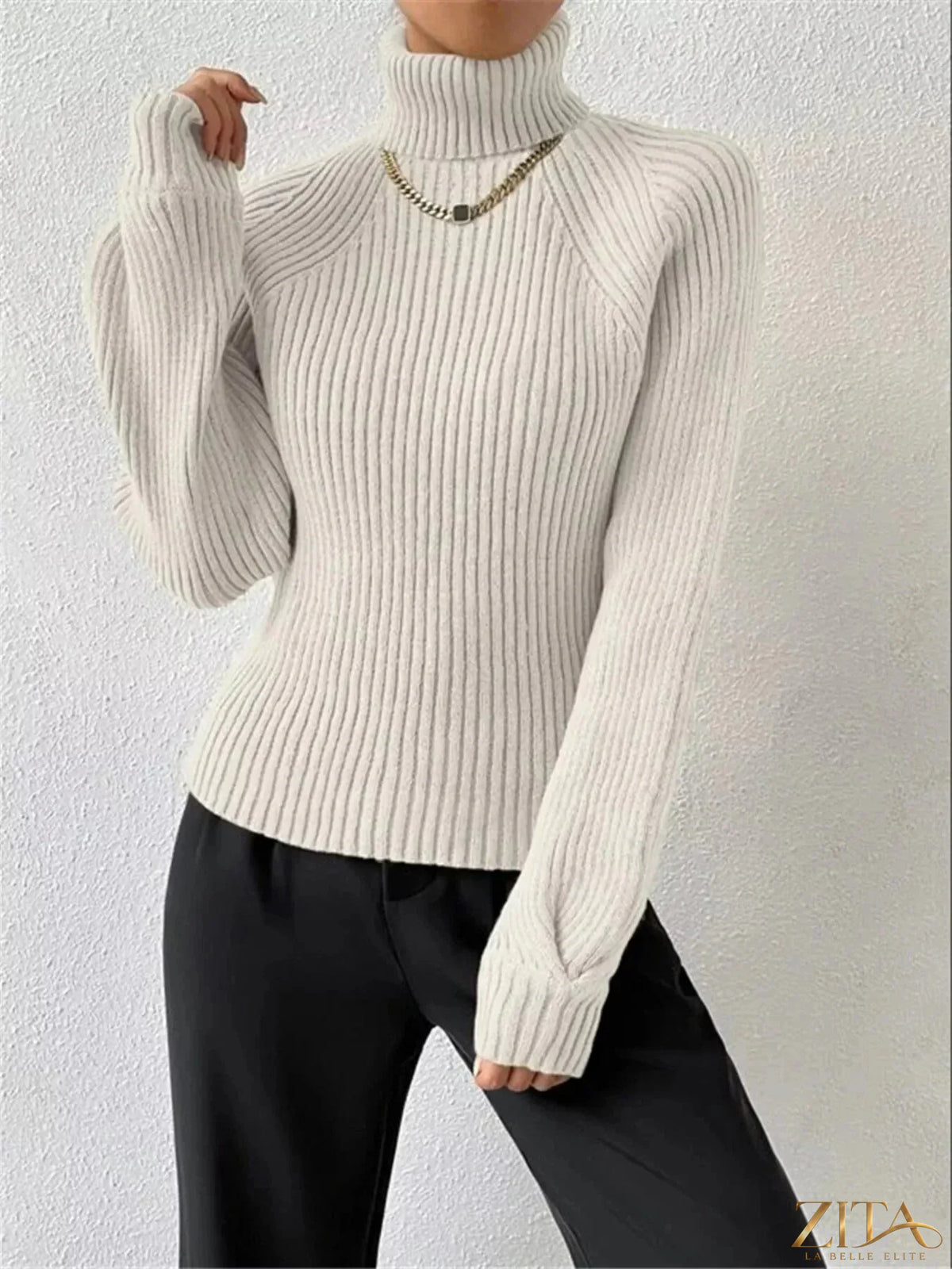 Zita La Belle Elite ribbed knit turtleneck sweater in neutral color, close-up view showing textured fabric and high neckline.