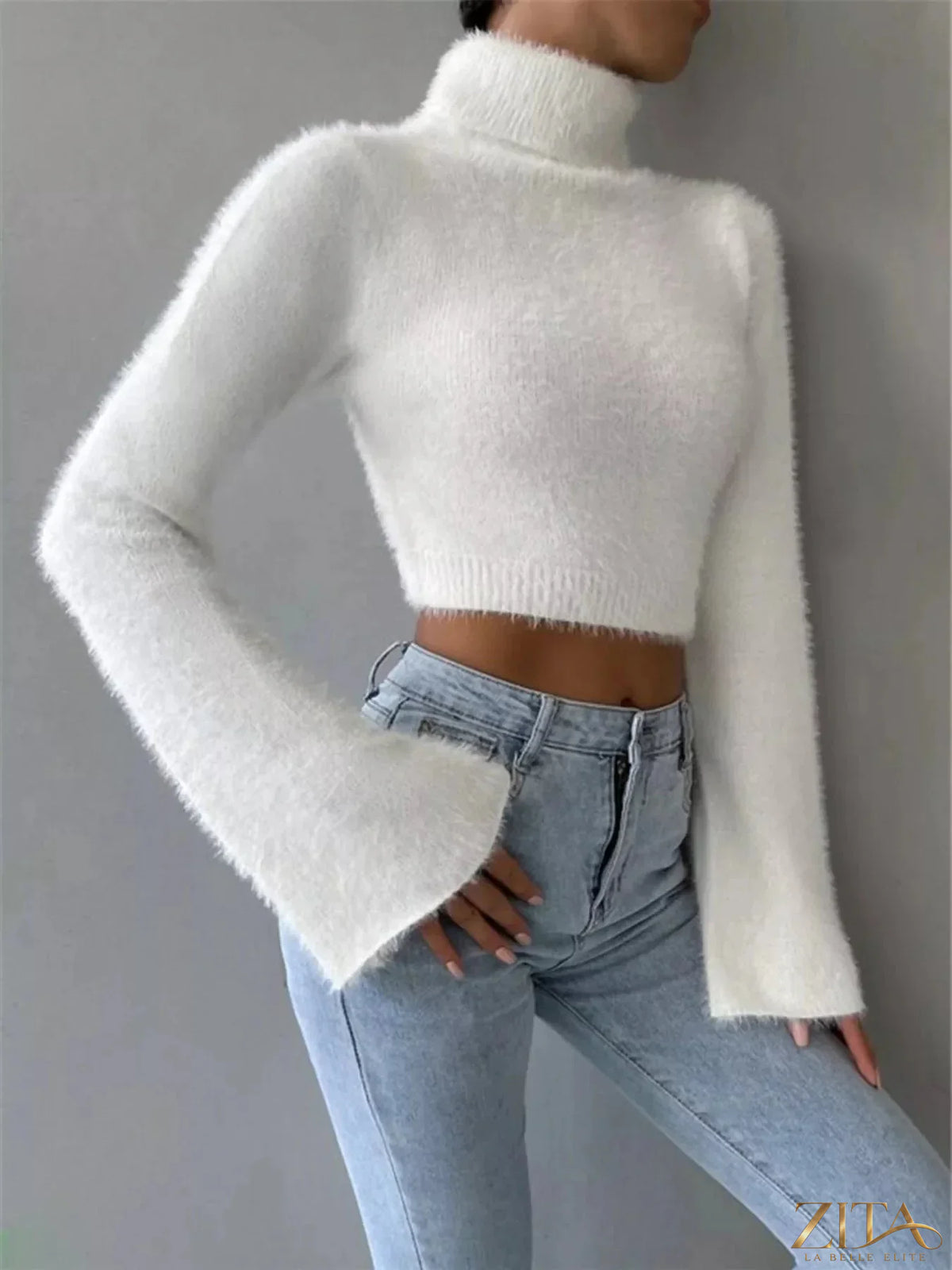 Cream turtleneck flare sleeve sweater by Trendsi, featuring a fitted turtleneck and dramatic flare sleeves on a model.