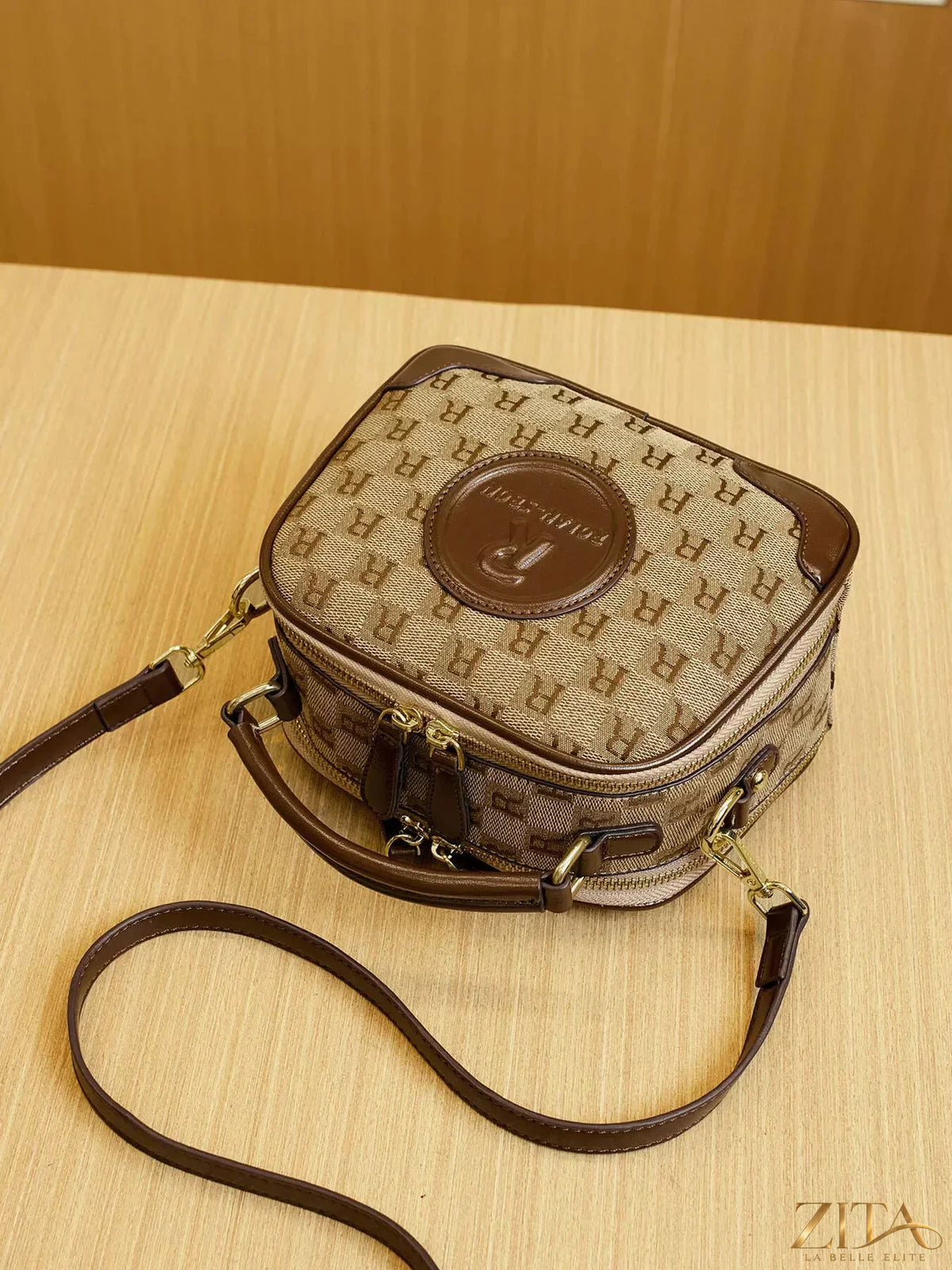 Zita La Belle Elite monogram pattern crossbody handbag with top handle, featuring a stylish and compact design with gold-tone hardware.