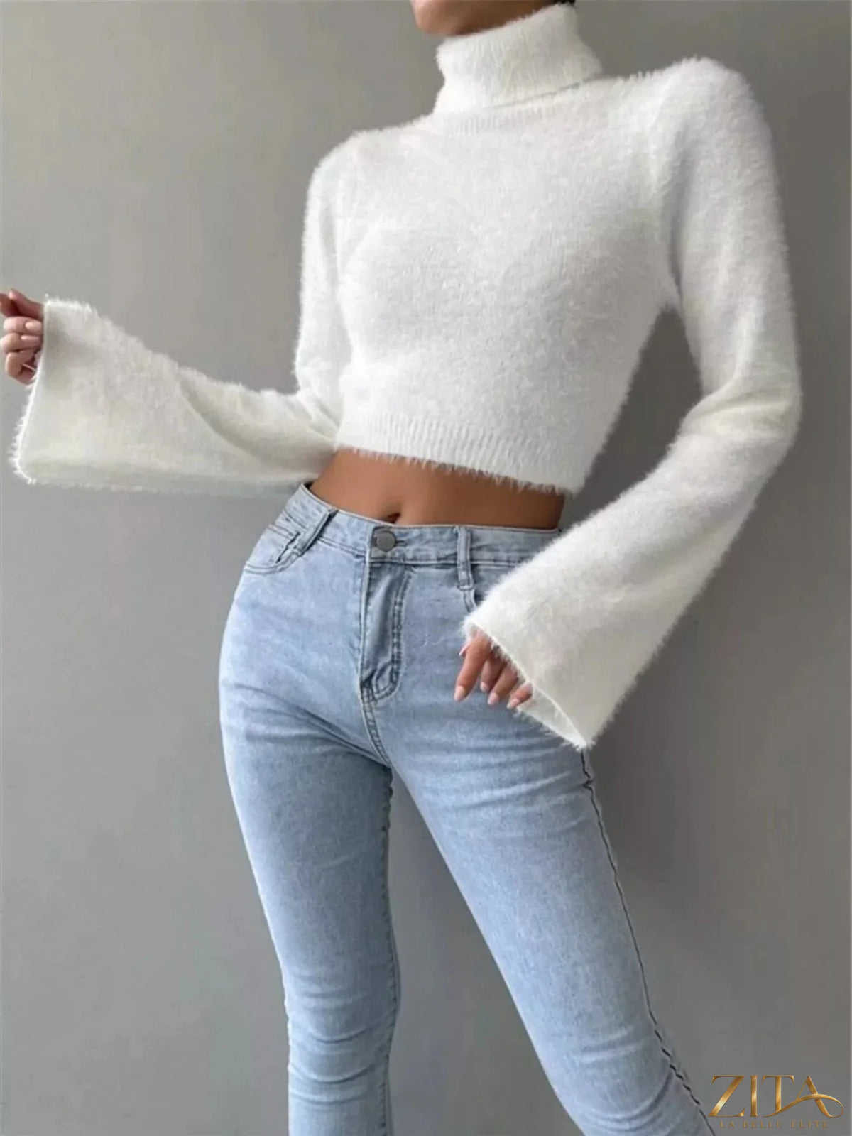 Cream-colored turtleneck flare sleeve sweater by Trendsi, featuring a fitted turtleneck and dramatic flare sleeves.