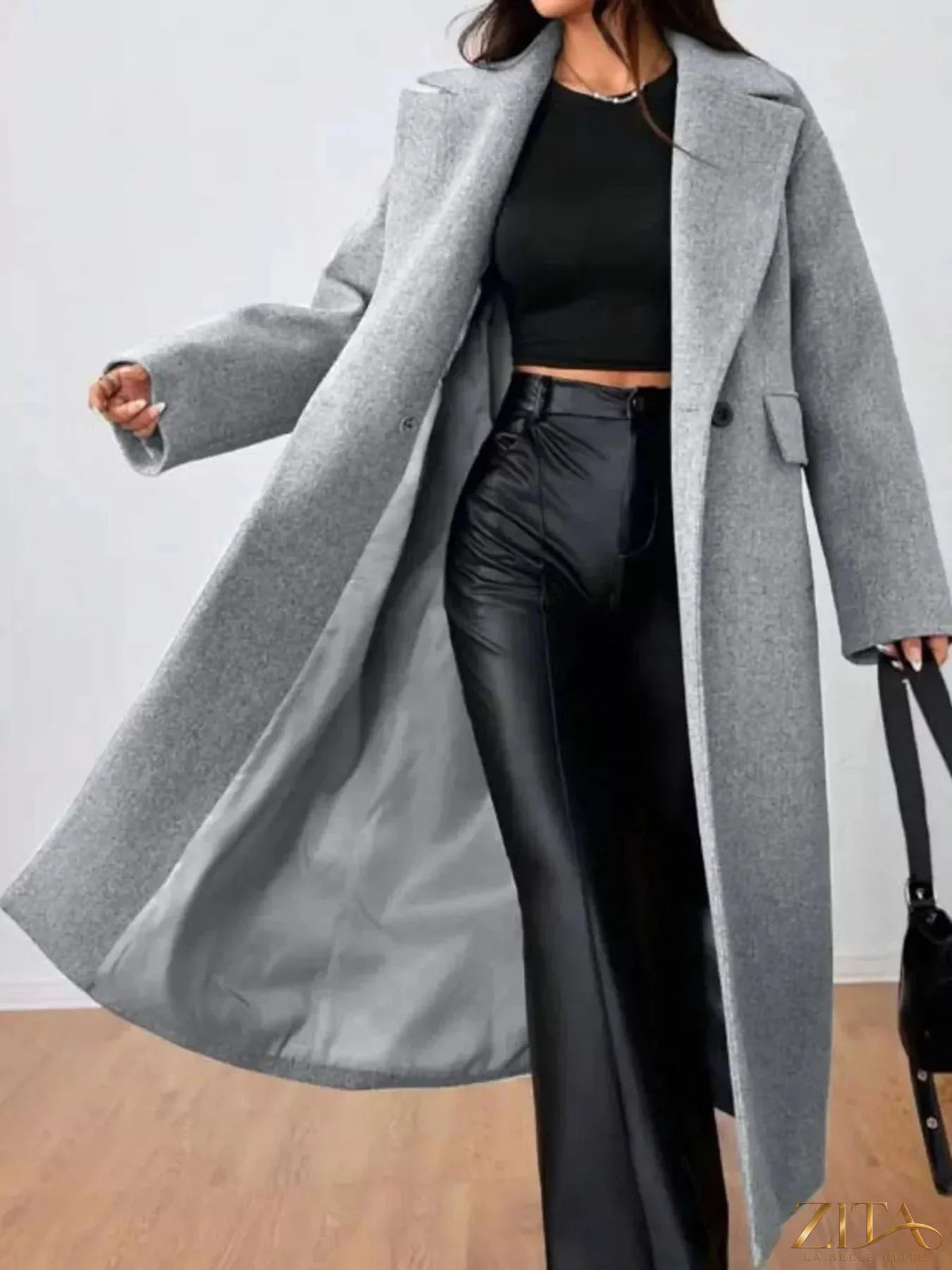 Zita La Belle Elite wool-blend longline overcoat hanging on a wooden hanger, showcasing its tailored design and cozy fabric.