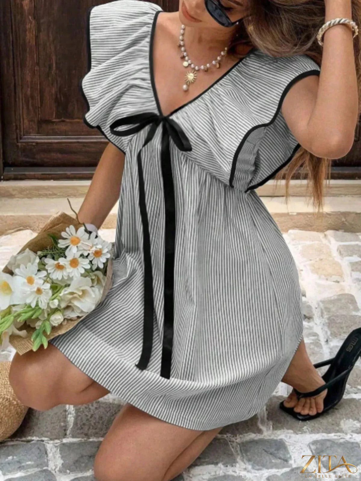 Striped ruffle sleeve mini dress from Trendsi featuring a playful pattern and flowy ruffle details on the sleeves.