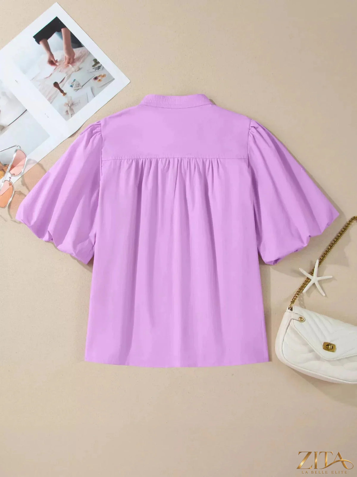 Zita La Belle Elite notched puff sleeve blouse featuring ruffled details and a feminine, stylish design on a white fabric background.