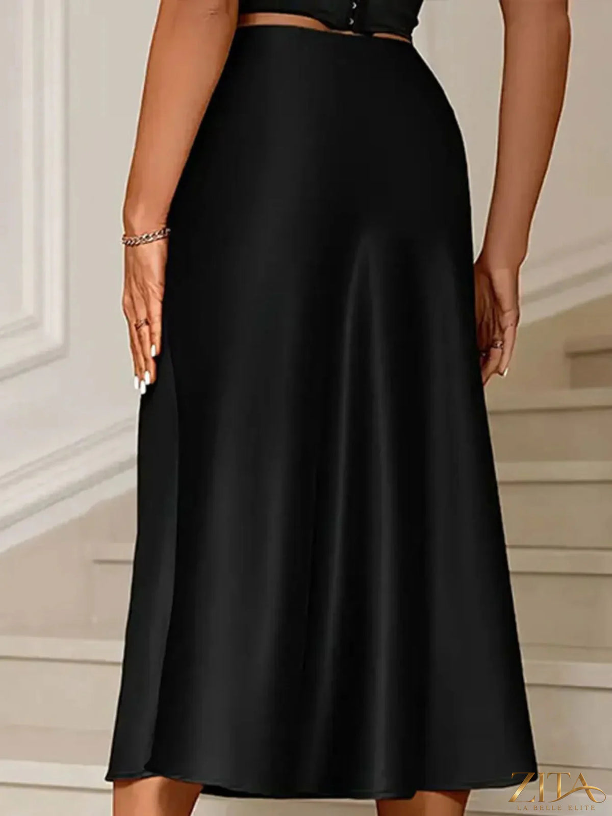 Satin midi mermaid skirt in smooth, shiny fabric with fitted waist and flared hem, styled for elegant fashion.