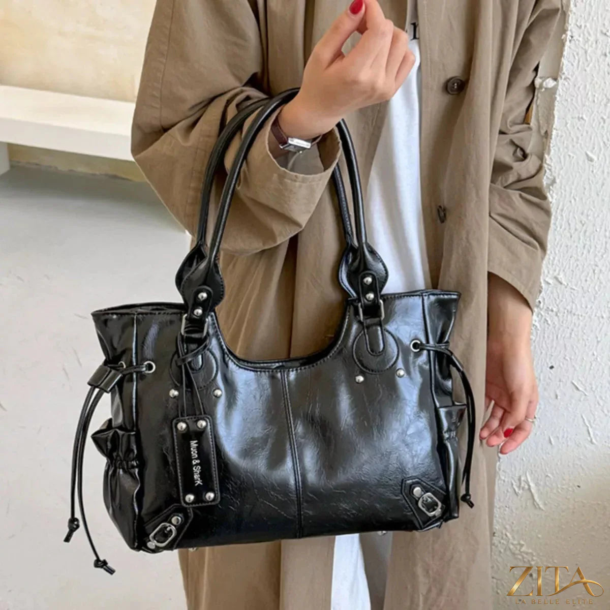 Drawstring leather handbag by Trendsi featuring a sleek design with a top handle and adjustable shoulder strap, shown in black leather.
