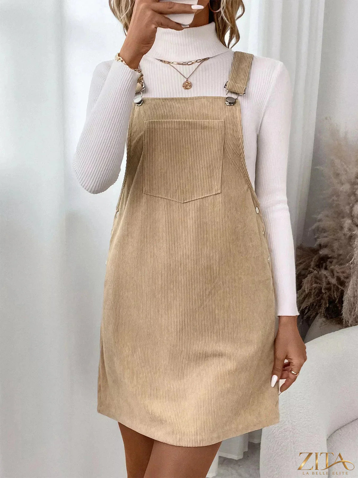 Zita La Belle Elite casual corduroy overall dress hanging on a wooden hanger, showcasing its stylish design and soft fabric.