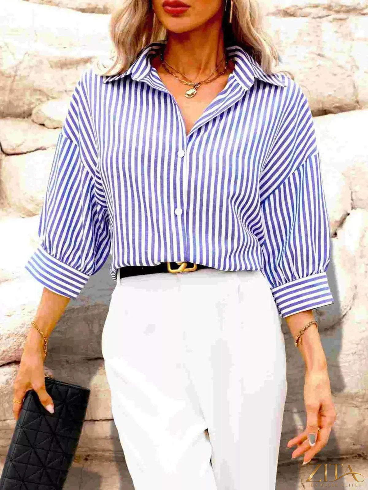 Zita La Belle Elite striped button-down shirt with blue and white vertical stripes, long sleeves and collar, laid flat.