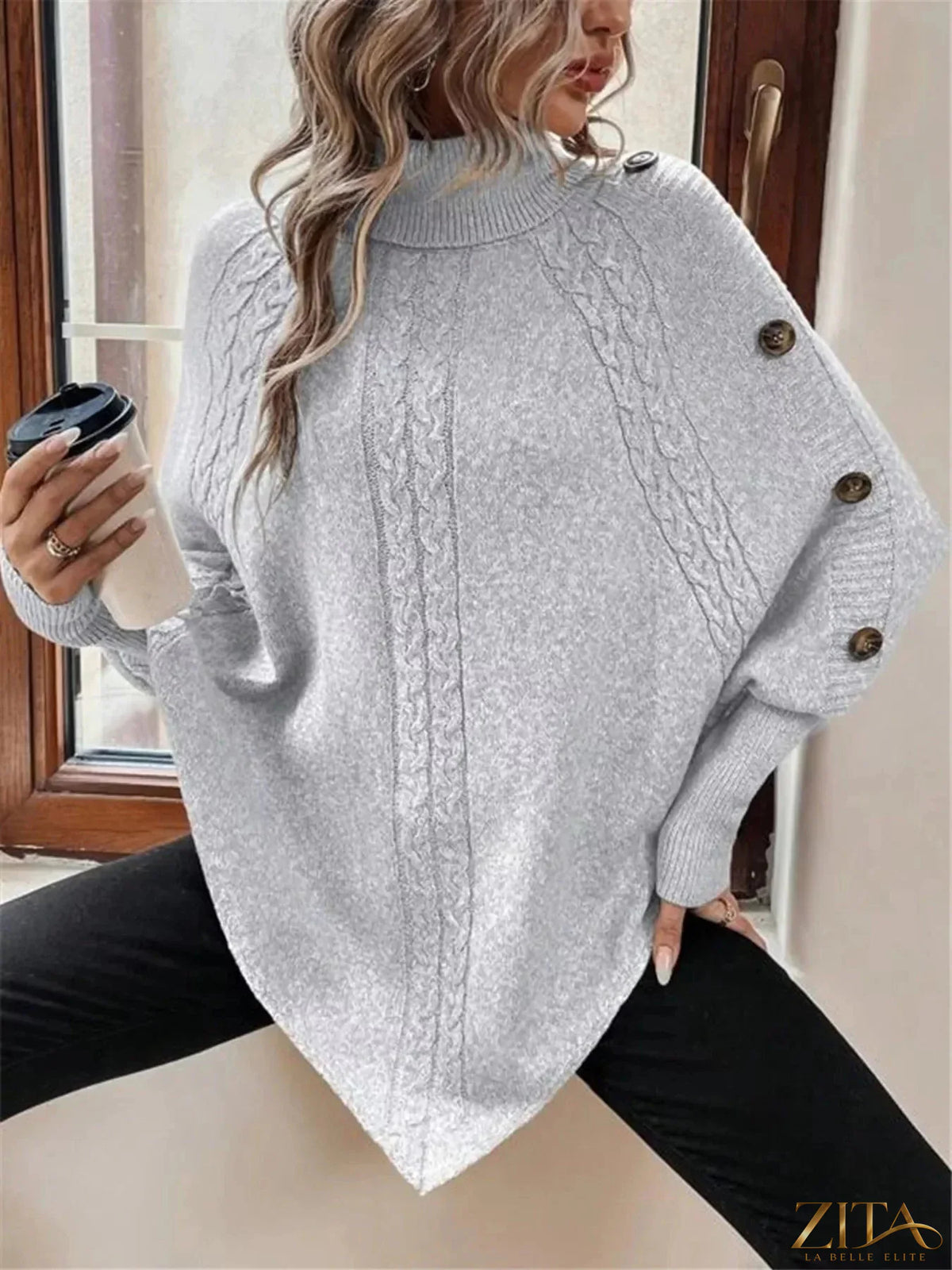 Cable knit turtleneck cape sweater by Trendsi featuring a cozy, textured design and a high neckline for stylish warmth.