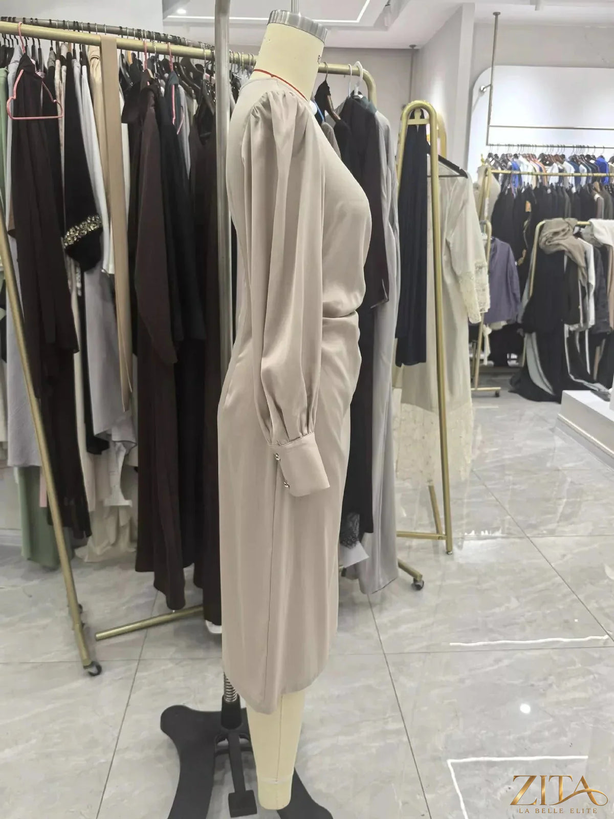 Zita La Belle Elite long sleeve satin ruched midi dress displayed on a hanger, showcasing its elegant fabric and fitted design.