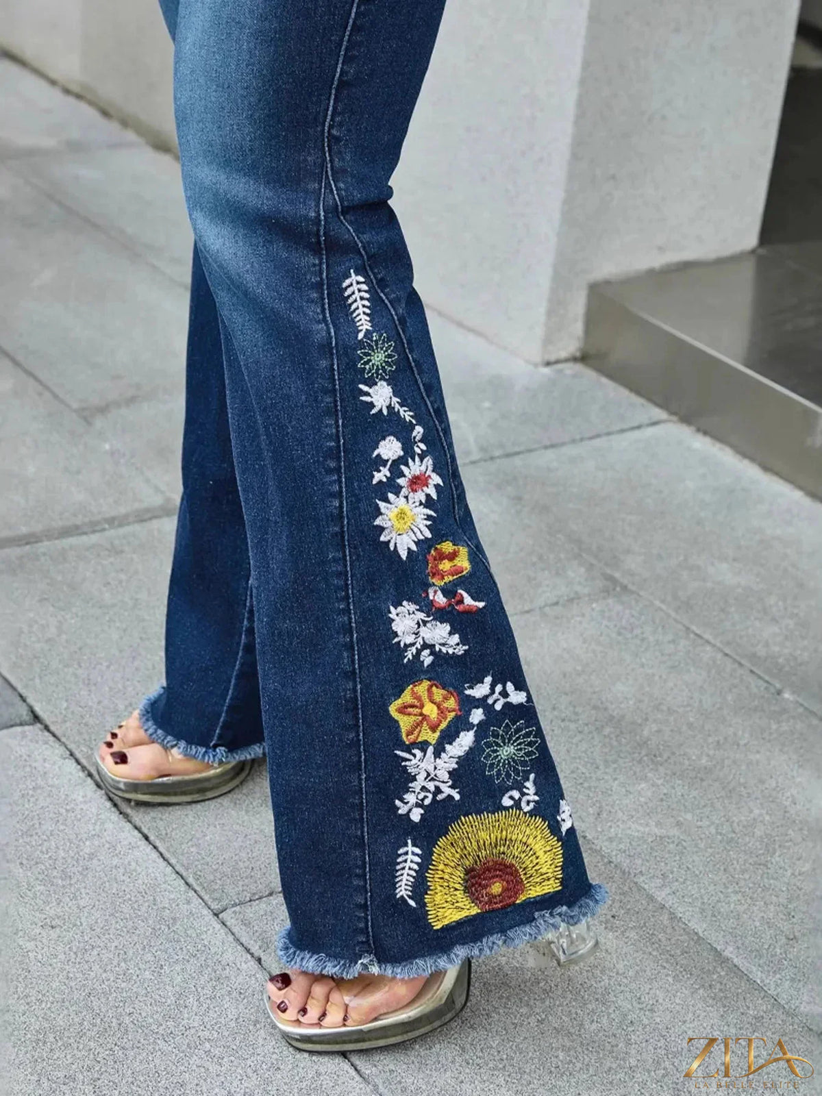 Raw hem embroidered high waist jeans by Zita La Belle Elite, showing detailed embroidery and distressed raw hem at the bottom.