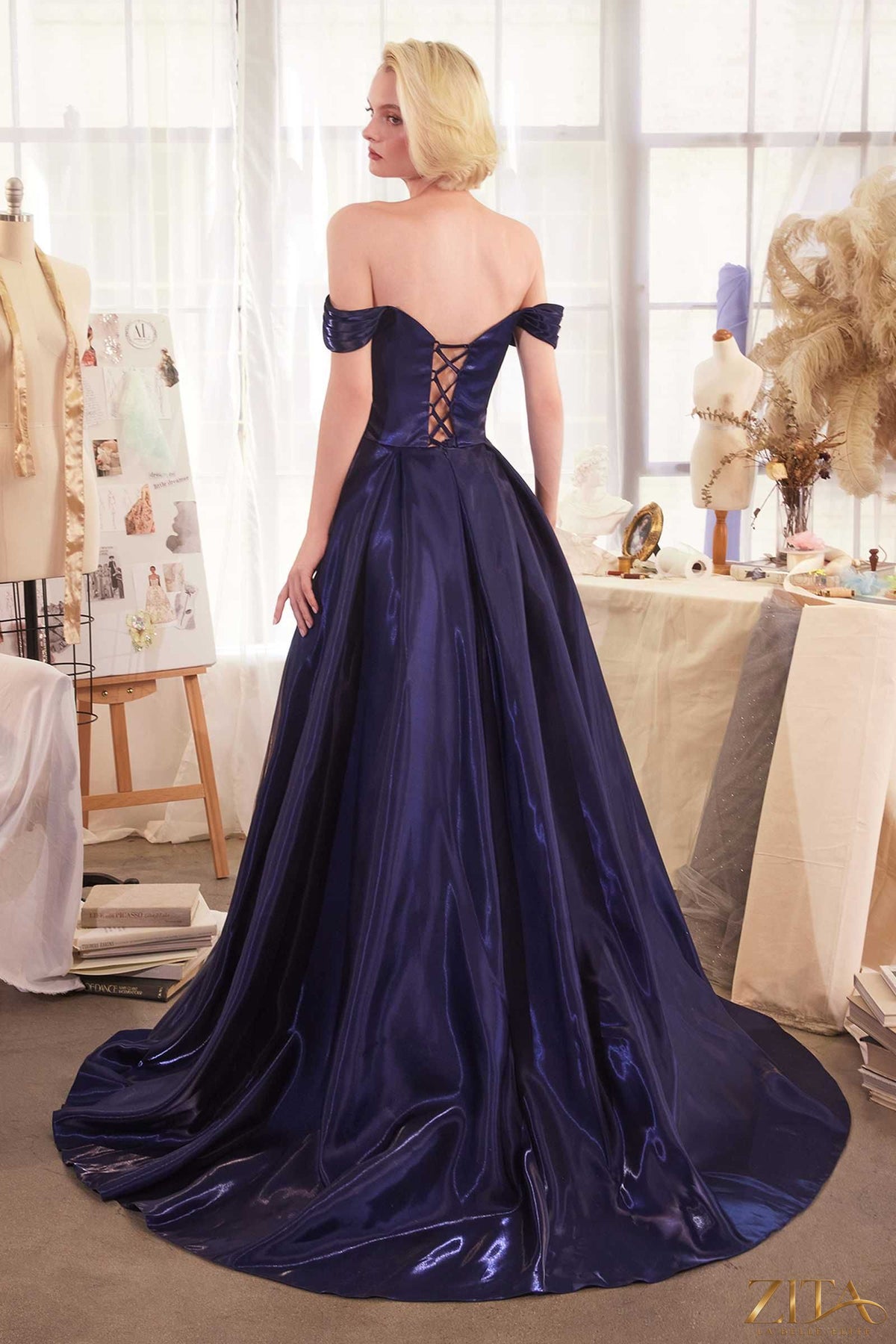 Navy blue off-the-shoulder organza ball gown by Zita La Belle Elite, featuring a flowing skirt and elegant neckline.