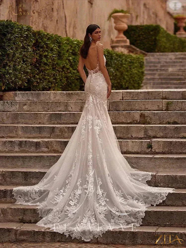 Luxury lace wedding gown with spaghetti straps by Zita La Belle Elite, featuring intricate lace details and a flowing, elegant design.