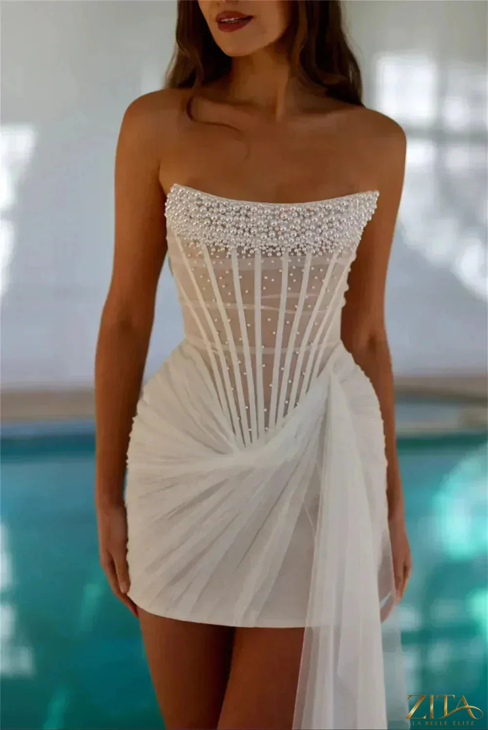 Ivory strapless pearl-embellished mini wedding dress with pleated skirt by Zita La Belle Elite, designed for bridal occasions