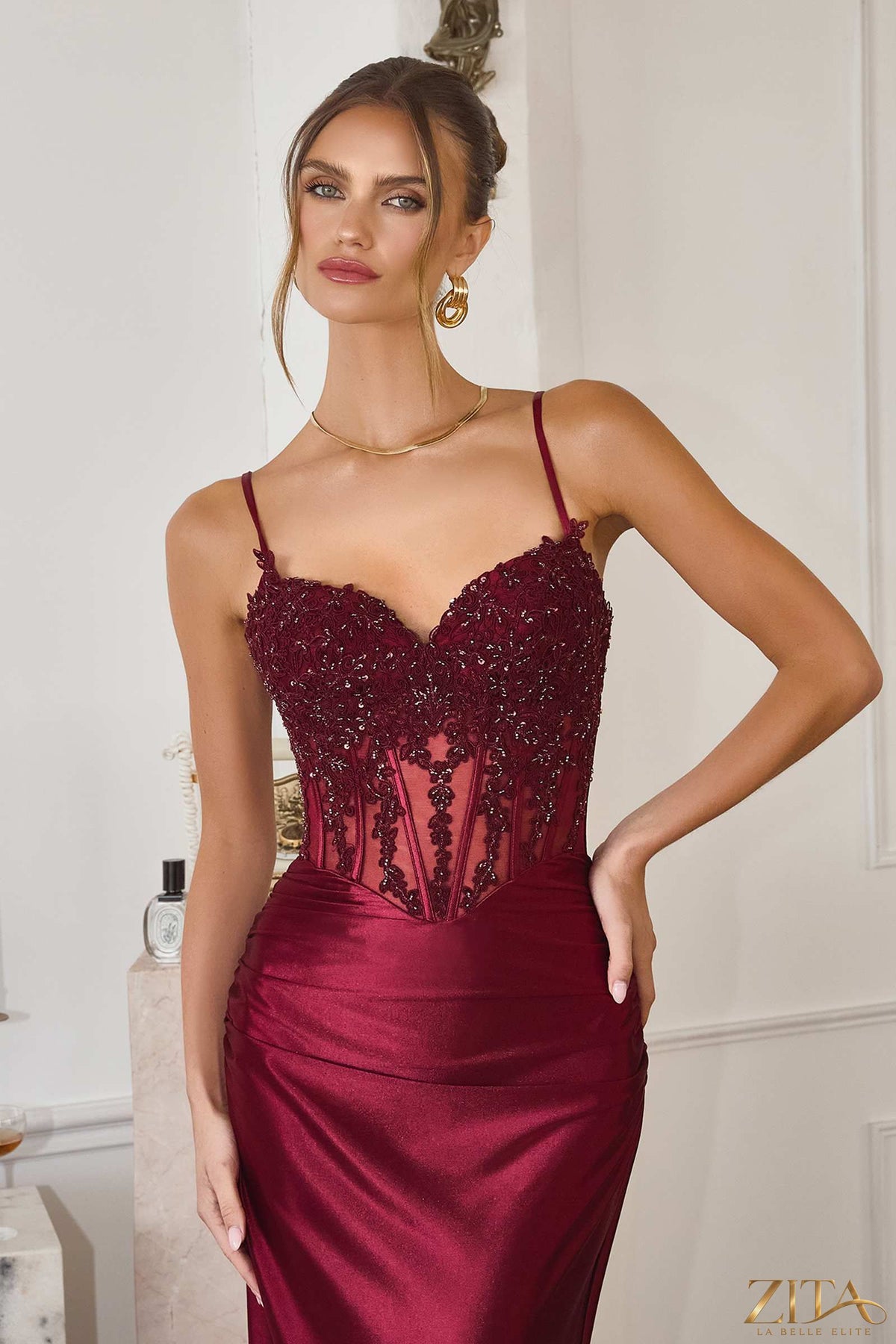 Burgundy fitted stretch satin sheer corset mermaid gown by Zita La Belle Elite, elegant dress with a sleek silhouette and intricate detailing.