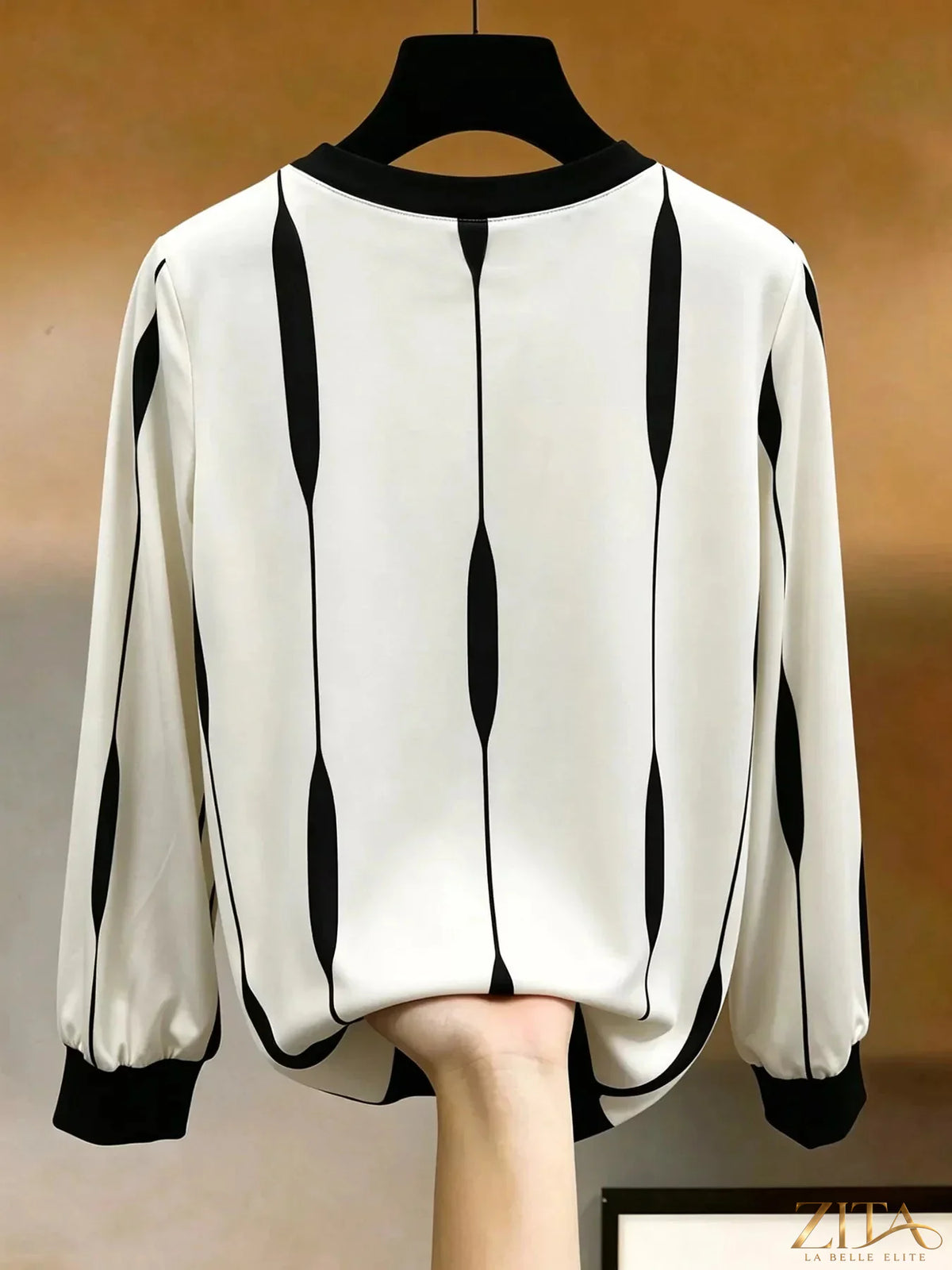 Zita La Belle Elite contrast vertical stripe long sleeve blouse with black and white pattern, displayed on a hanger.