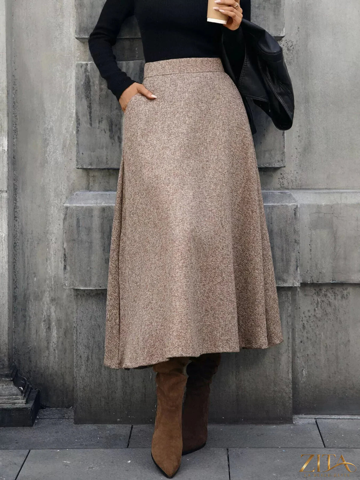 A-line midi skirt from Trendsi featuring a flowy design and high waist, shown in a neutral fabric with a smooth texture.