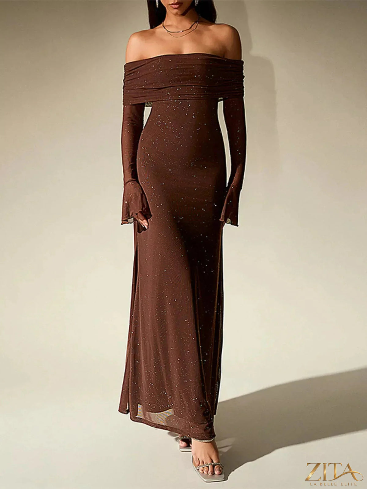 Zita La Belle Elite glitter off-shoulder maxi dress with a flowing silhouette and shimmering fabric, styled on a model.