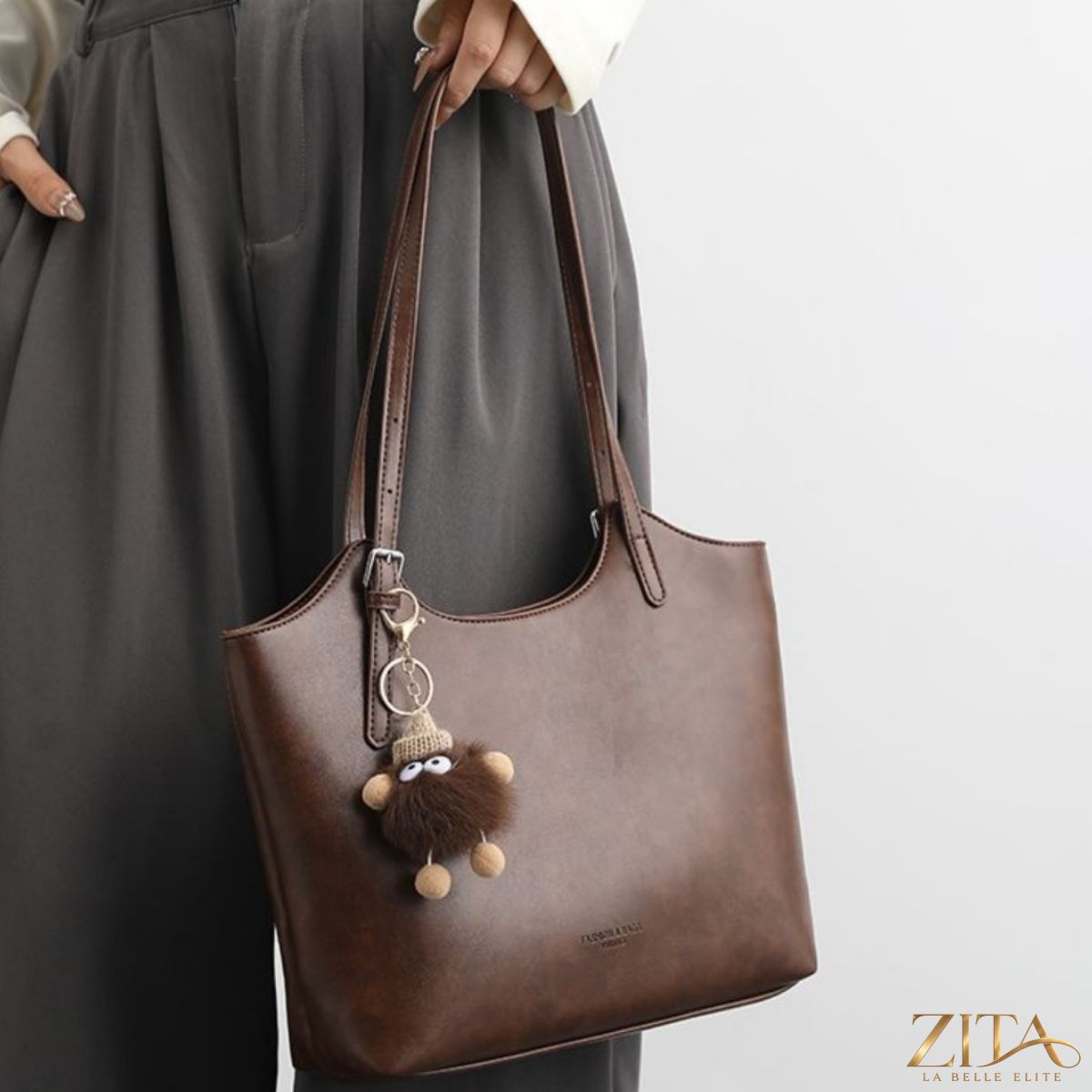 Zita La Belle Elite leather tote bag with decorative charm, featuring sturdy handles and spacious interior for everyday use.