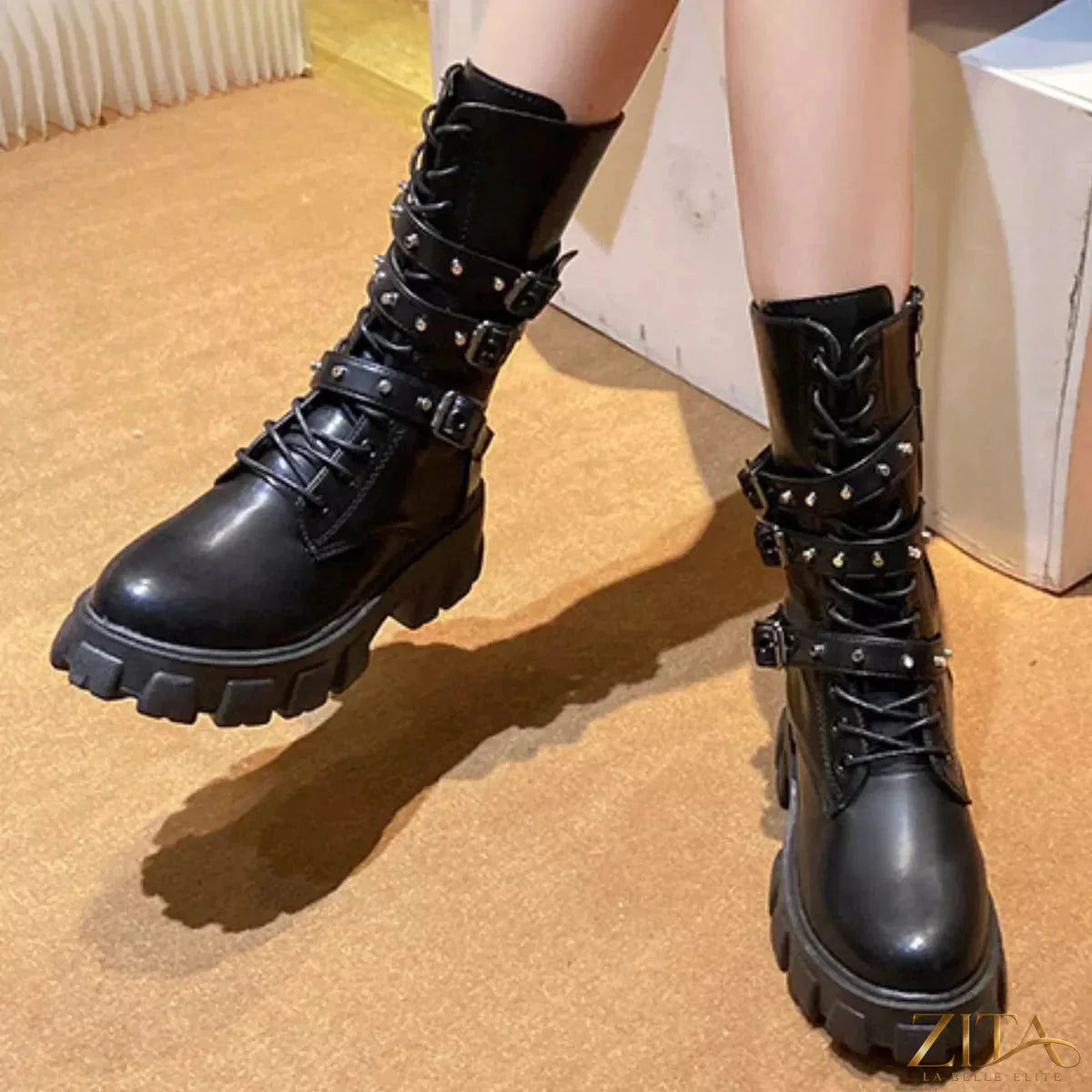 Black buckled lace-up combat boots by Trendsi featuring sturdy soles and metal eyelets, styled with denim jeans.