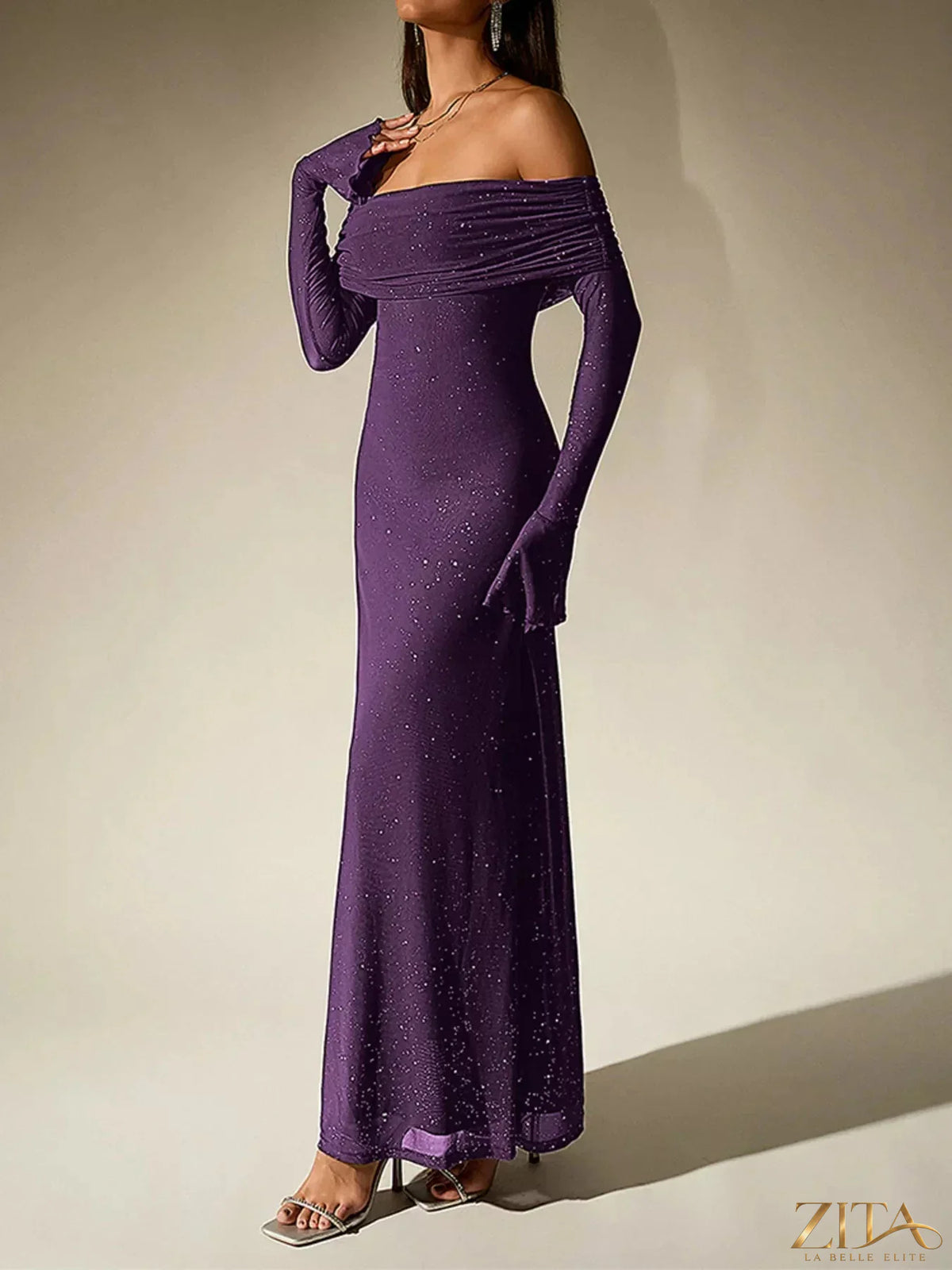 Glitter off-shoulder maxi dress by Zita La Belle Elite featuring a sparkling fabric and flowing silhouette on a model.