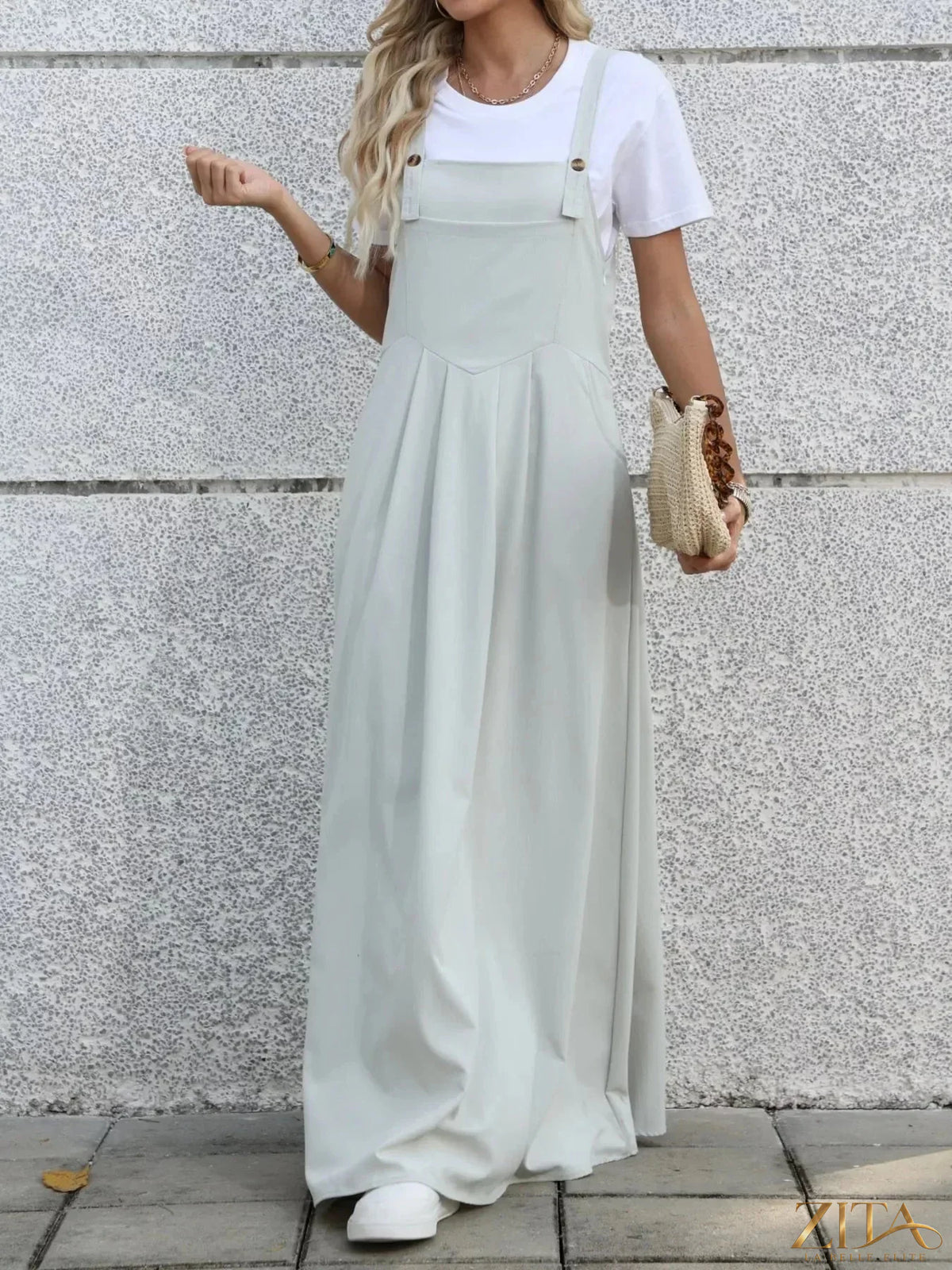 Zita La Belle Elite pleated detail overall dress shown on a model, featuring a stylish, flowy design with wide straps and a fitted waist.