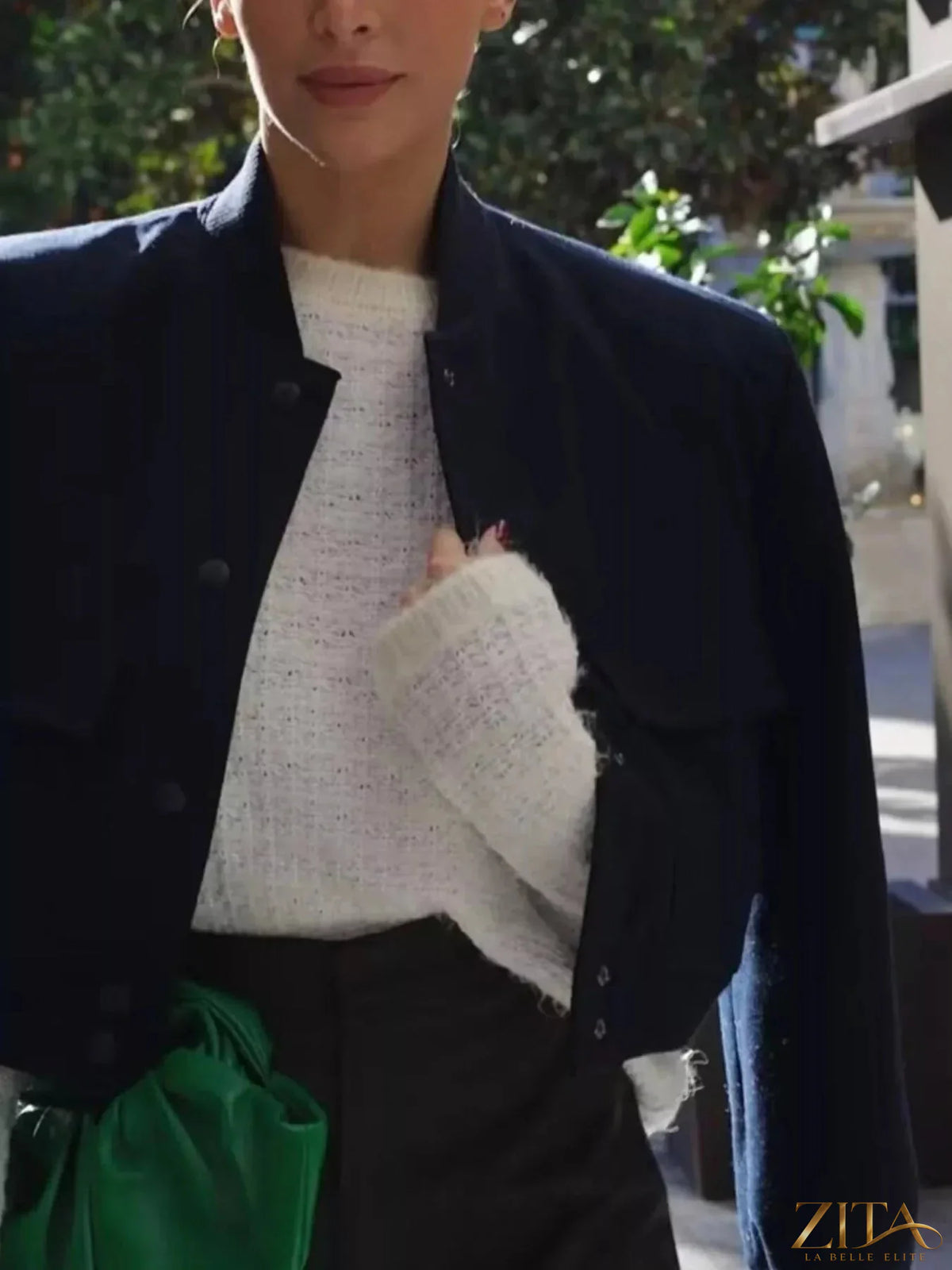 Zita La Belle Elite snap-down cropped bomber jacket in black with ribbed cuffs and collar, displayed on a hanger.
