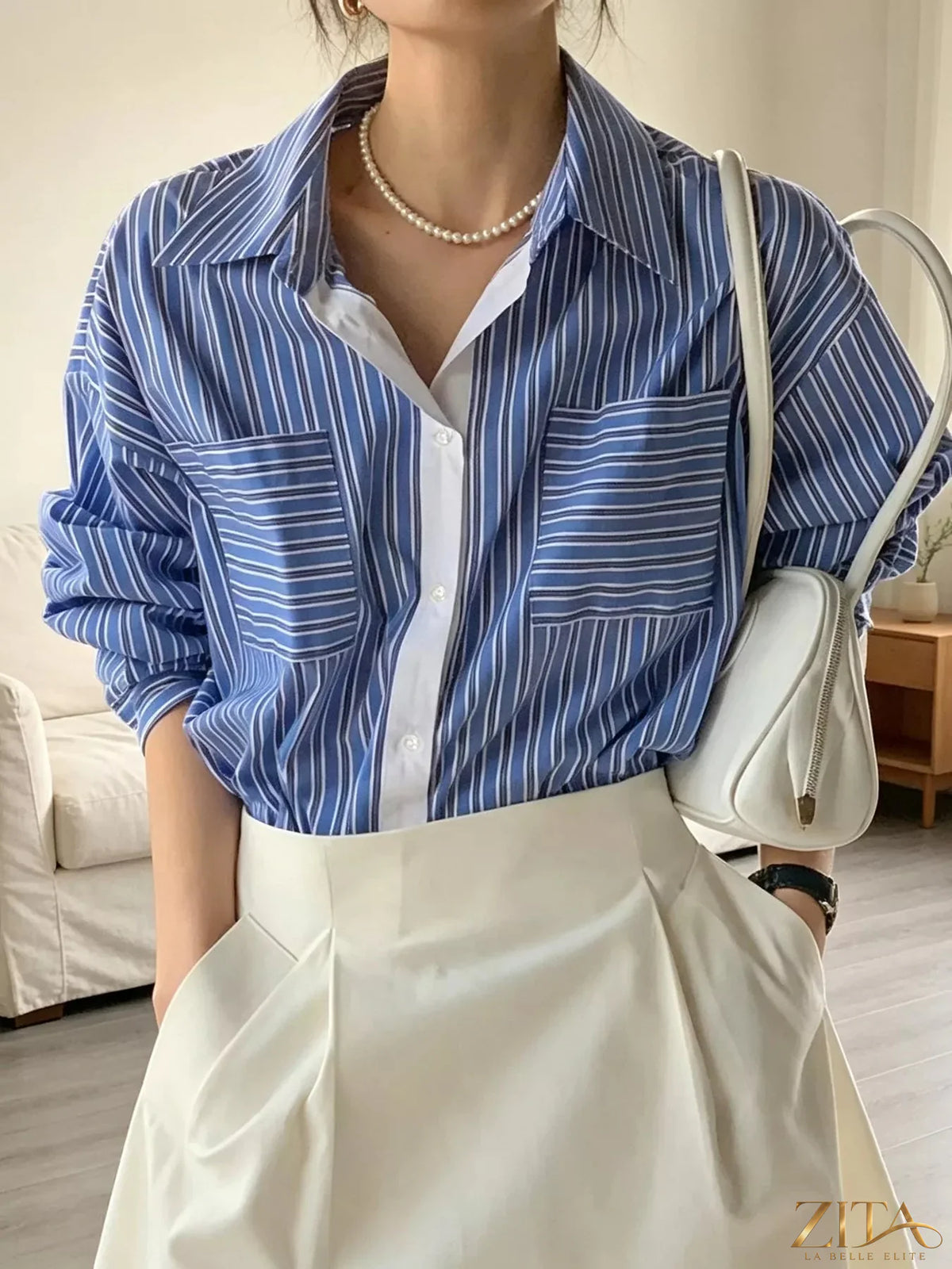 Zita La Belle Elite striped button-down shirt with blue and white vertical stripes, long sleeves, and collar.