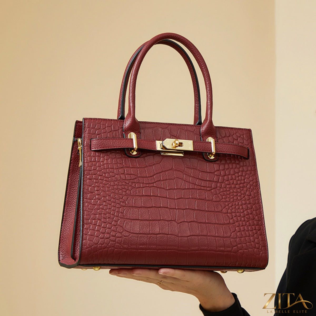 Crocodile-embossed leather top handle handbag by Zita La Belle Elite with gold hardware and structured design.